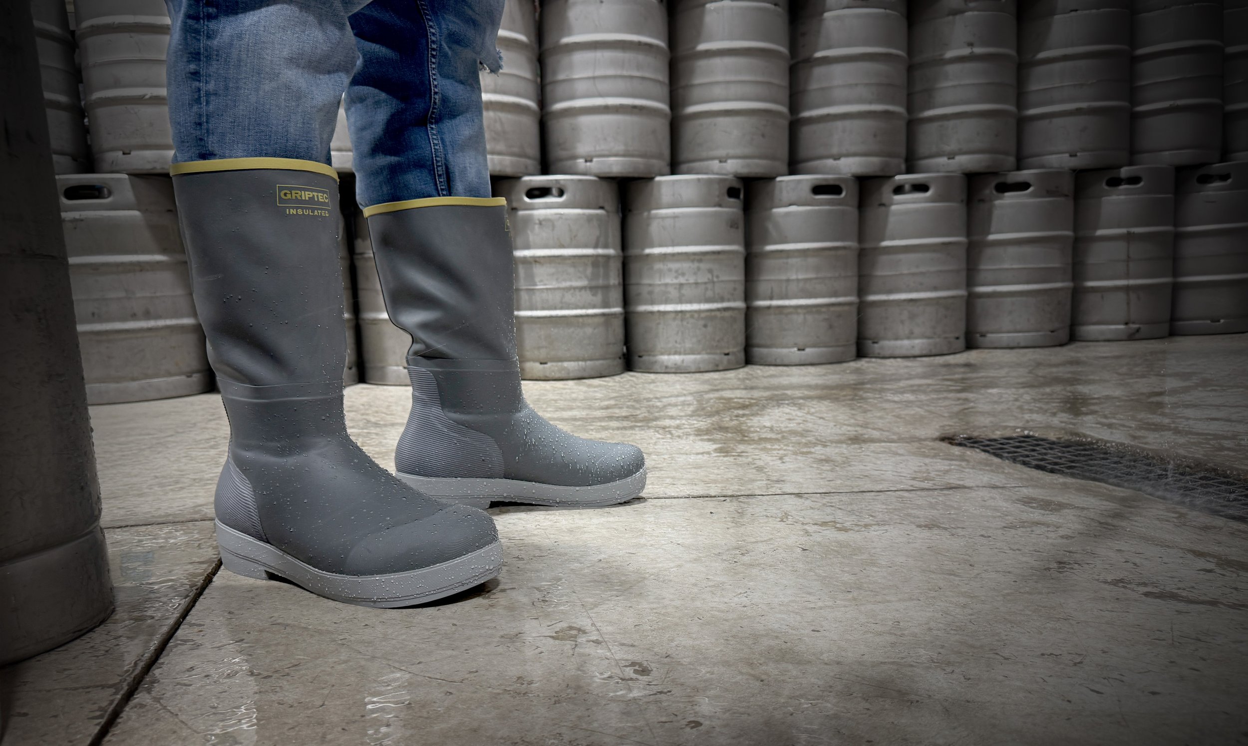 Tahma waterproof boots at a brewery standing in front of a wall of kegs