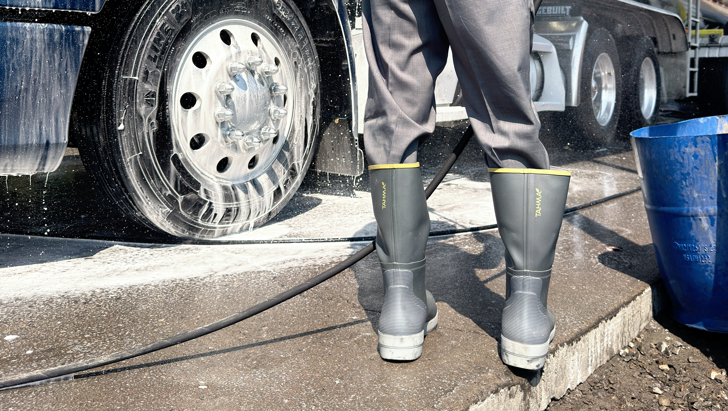 Tahma 15 tall boot worn by worker power washing a semi truck
