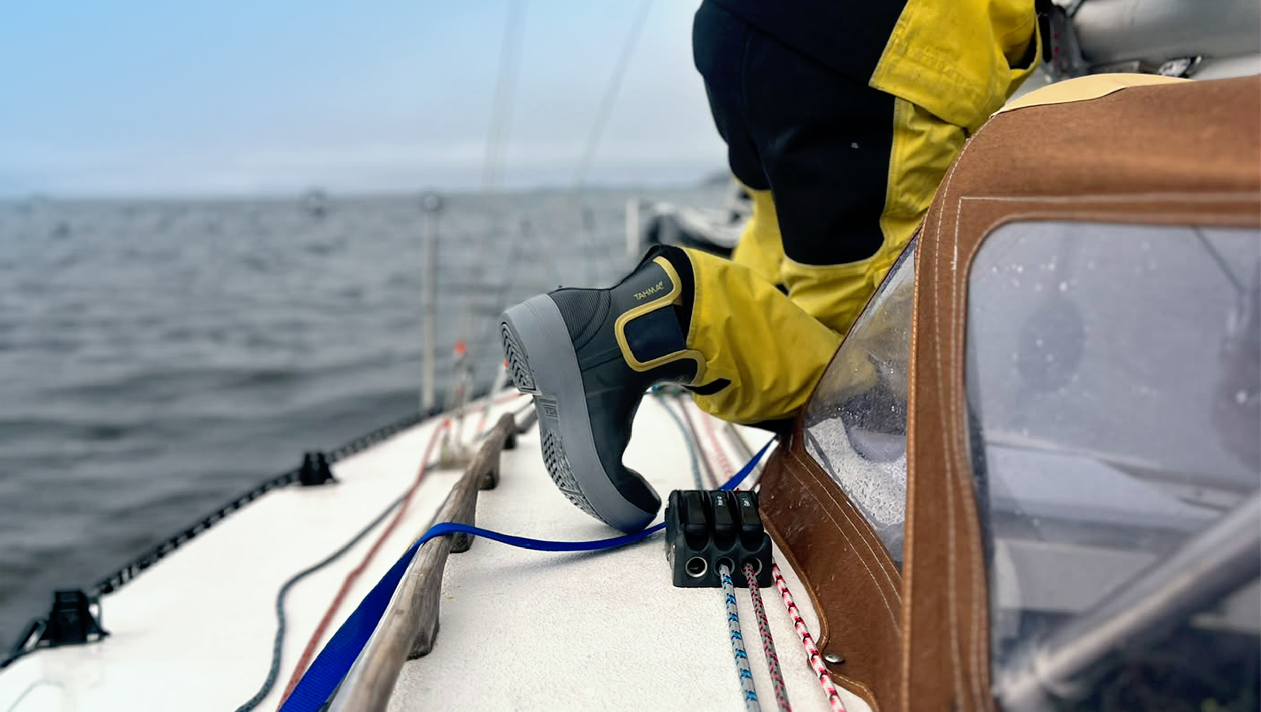 customer wearing low-cut Tahma boots on a deck of a sailing boat