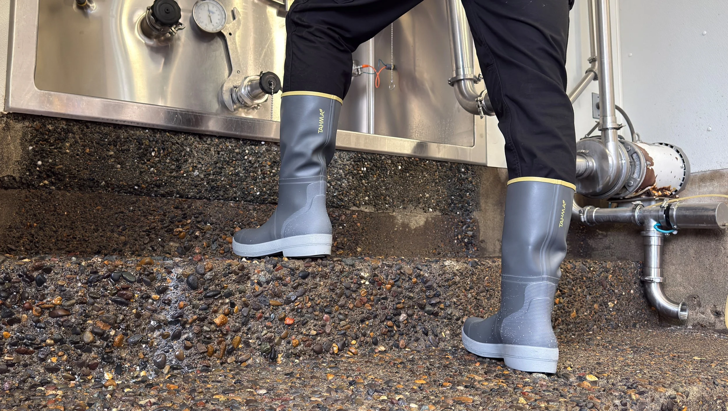Tahma 15 inch tall boots at a dairy farm in front of a milk silo container