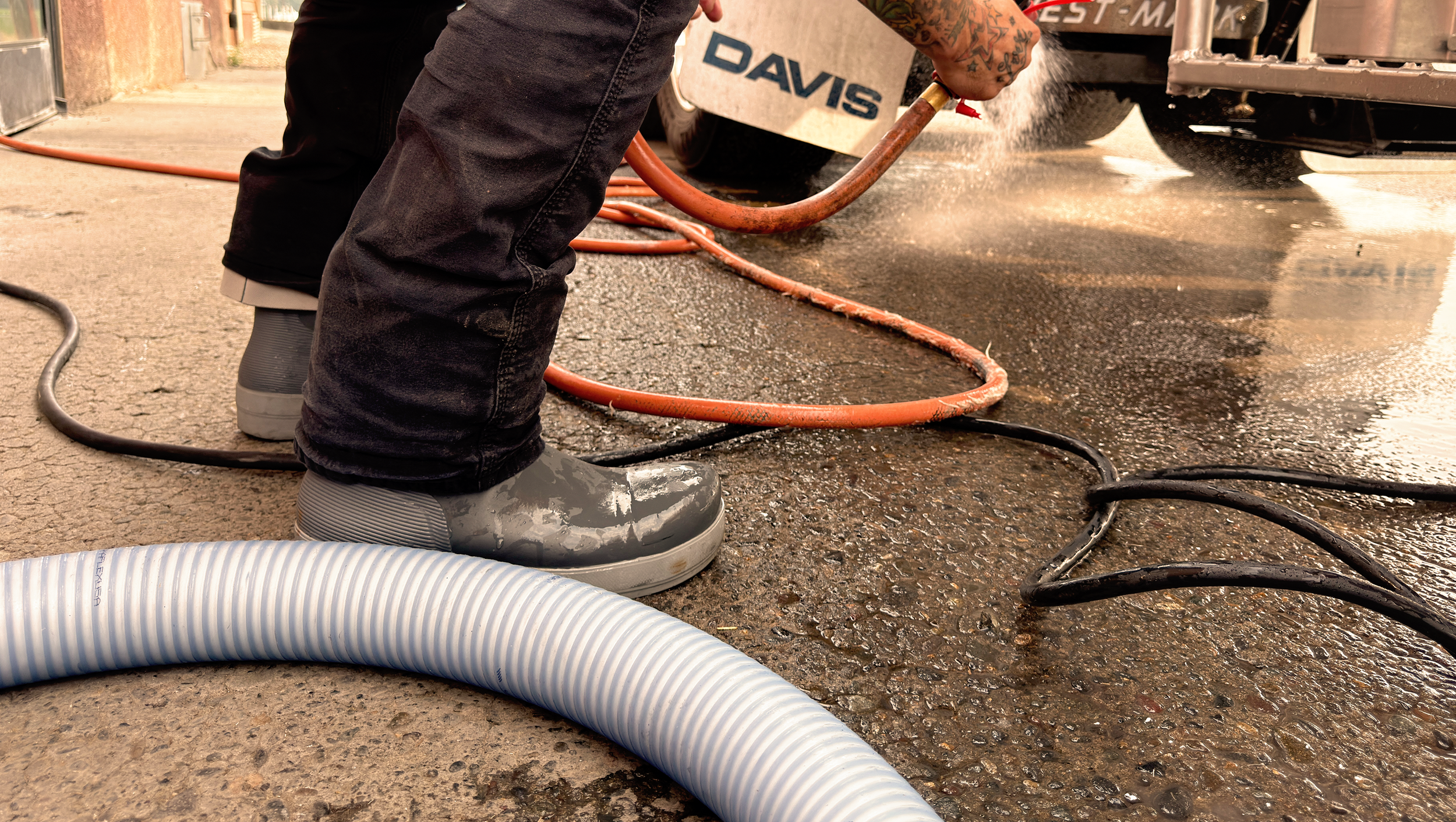 Tahma boots getting wet and dirty while transferring dairy milk to his tanker truck