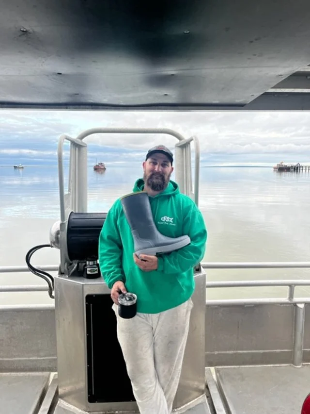 Tahma boot being held by commercial fishing captain on the bridge of a boat on the ocean