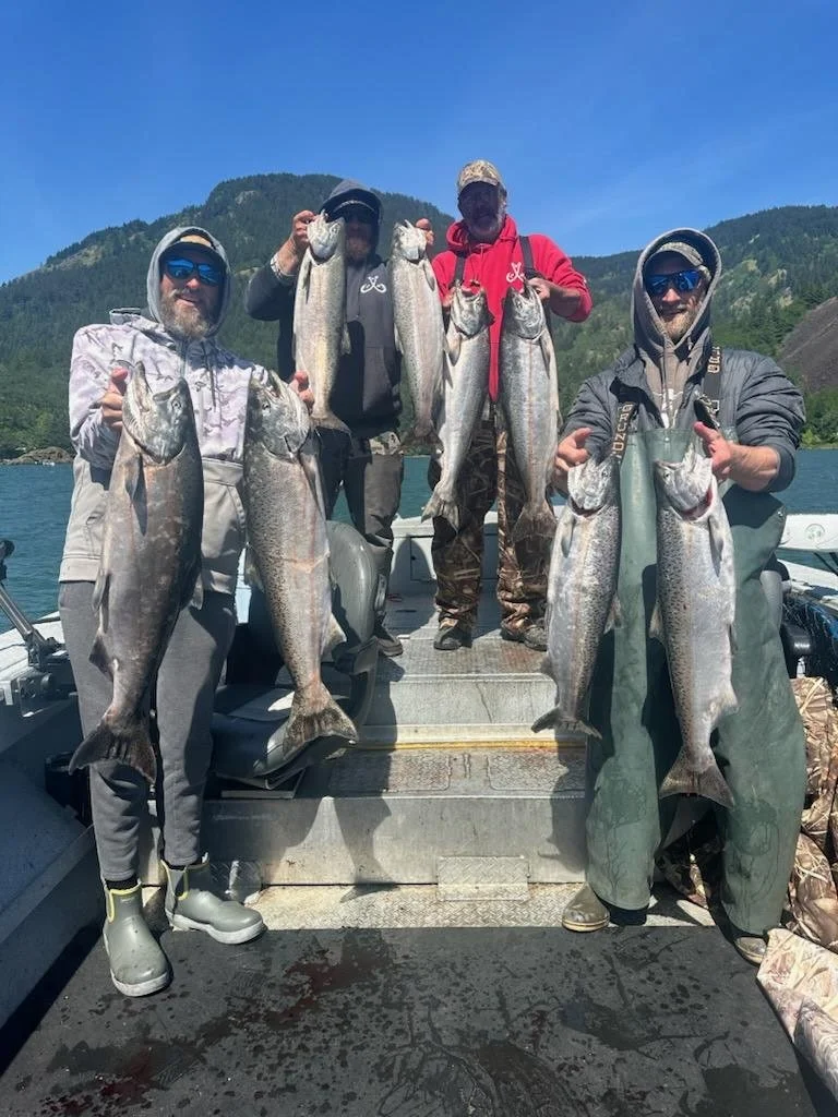 Customers wearing Tahma boots on a fishing boat holding their catch of the day