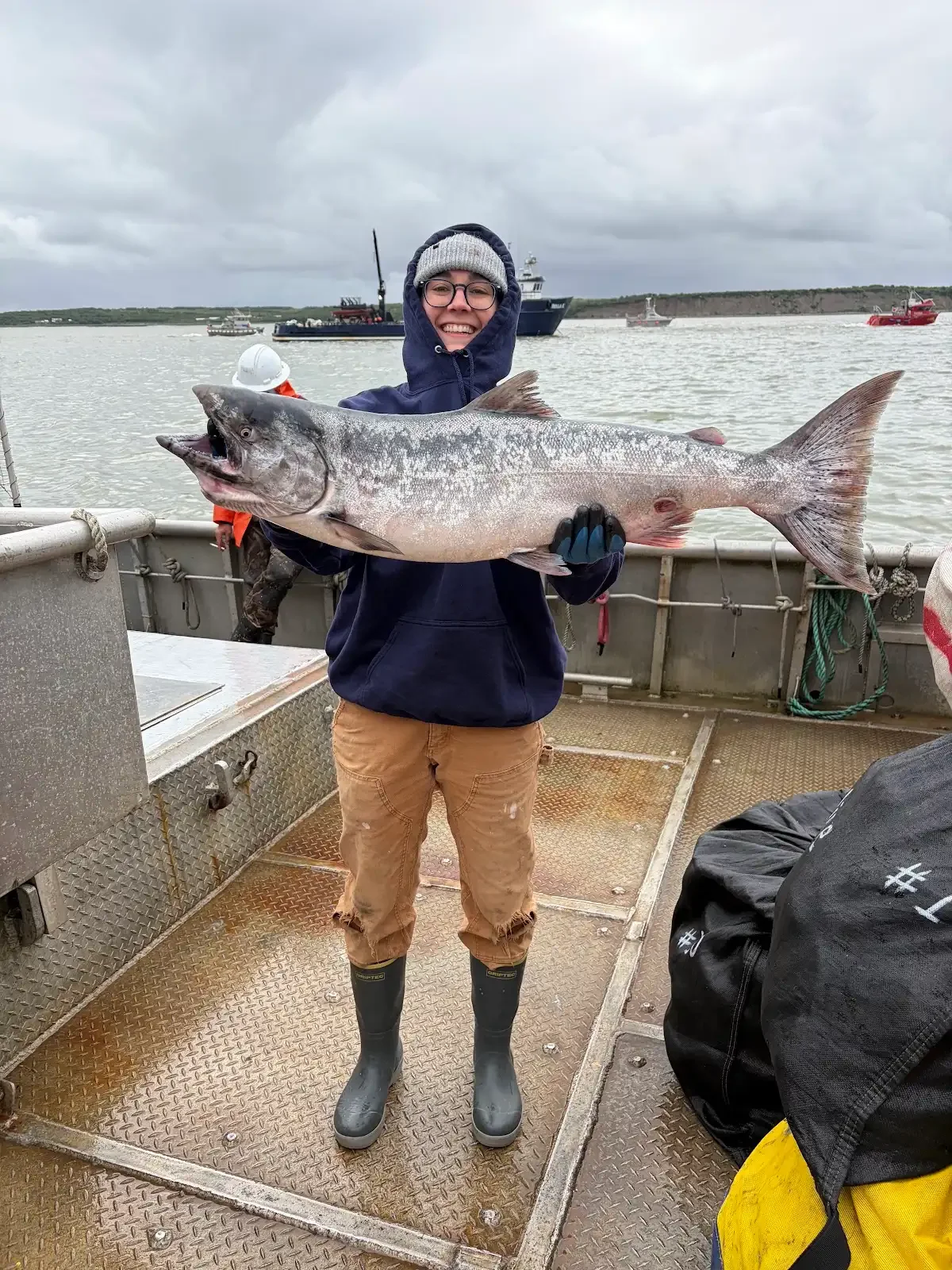Commercial fisherman holding their giant fish wearing Tahma boots