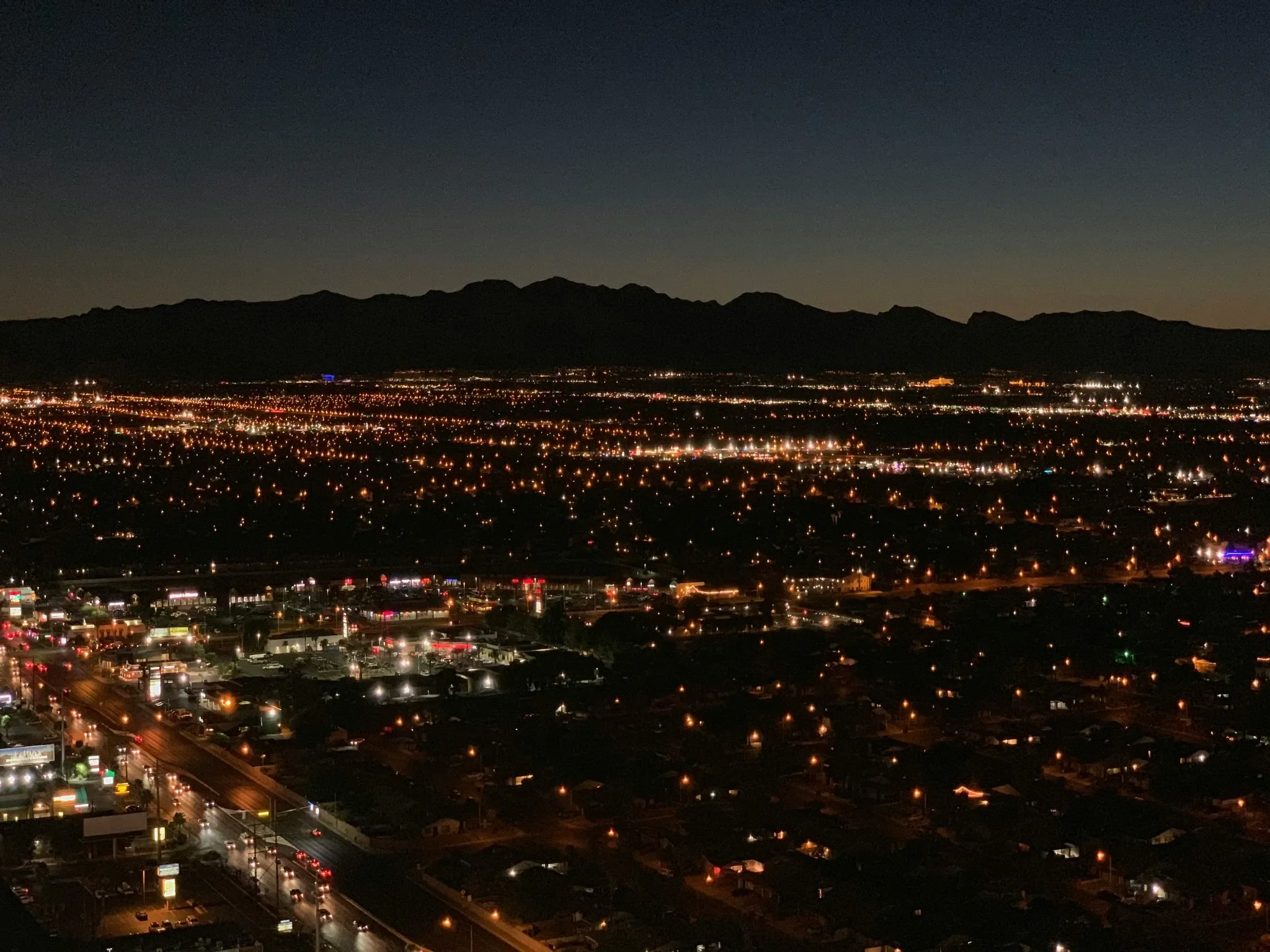 Las Vegas Valley city lights at night with mountain silhouettes in the background.