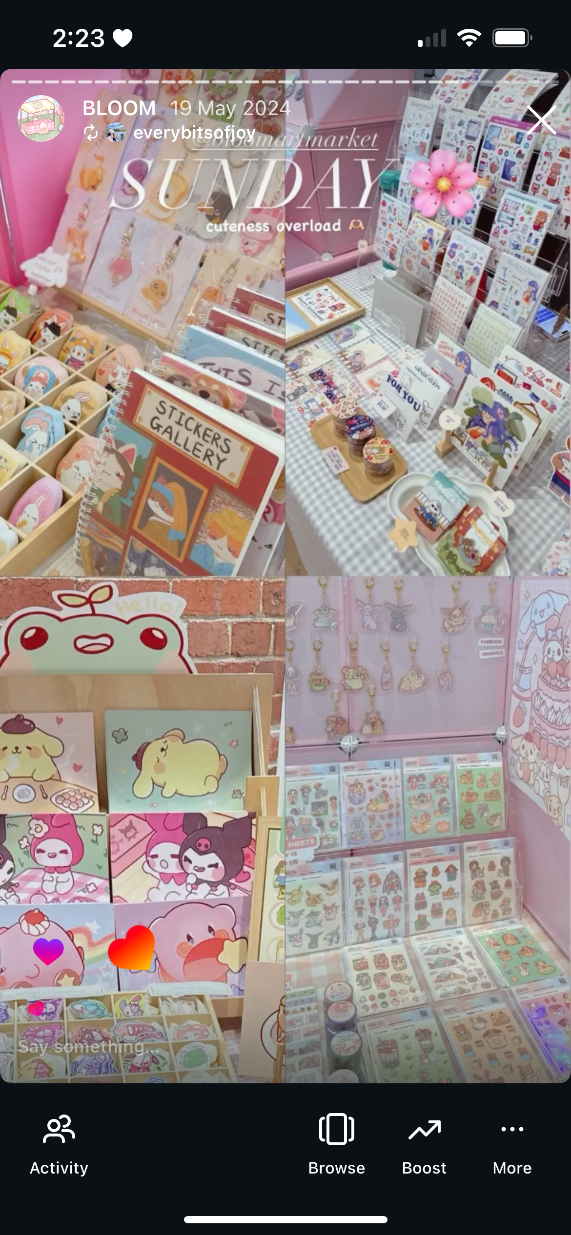 Display of various cute stationery and accessories, including sticker books, pins, notepads, and character-themed items in a brightly lit shop.