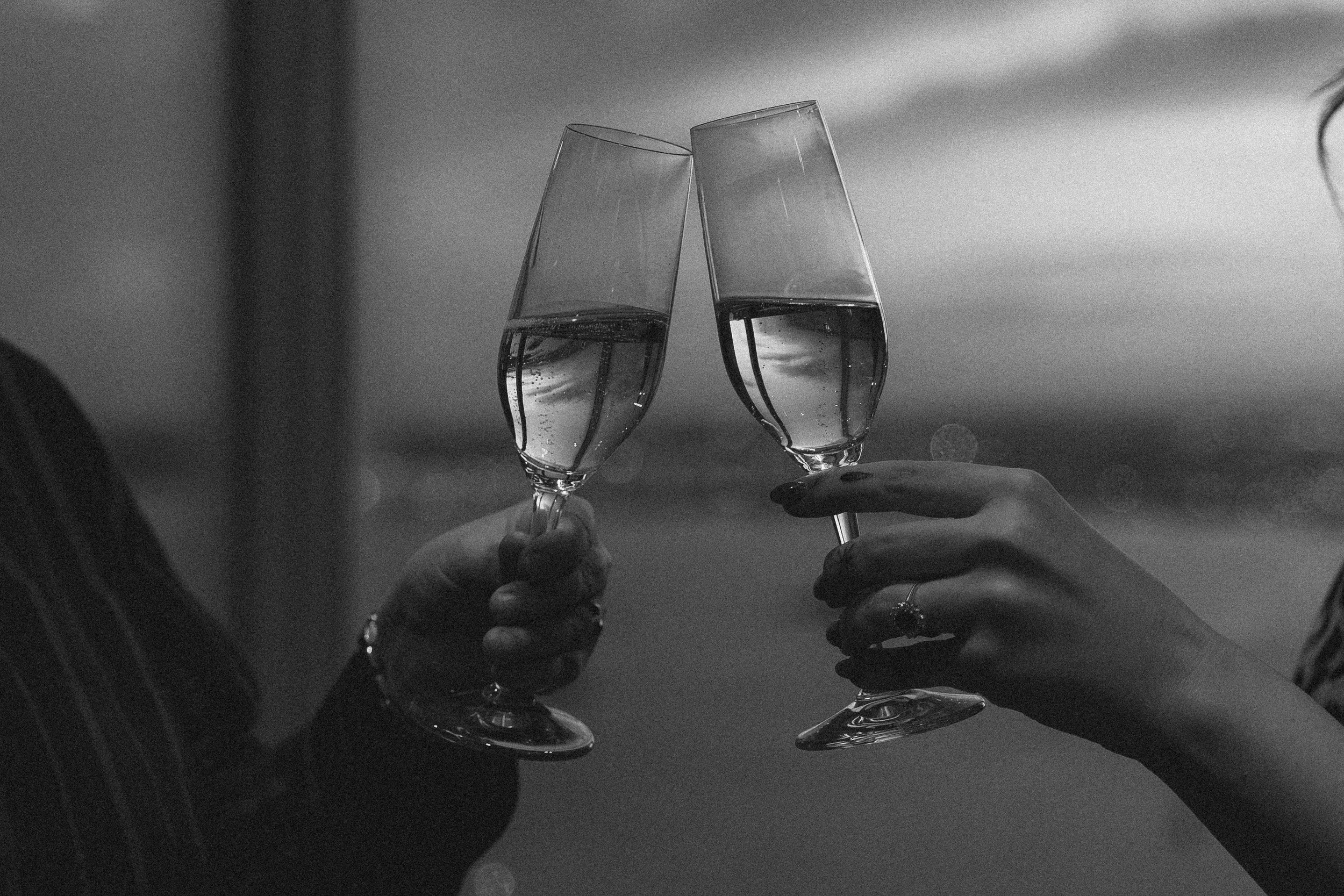 Two people clinking glasses of champagne in a toast.