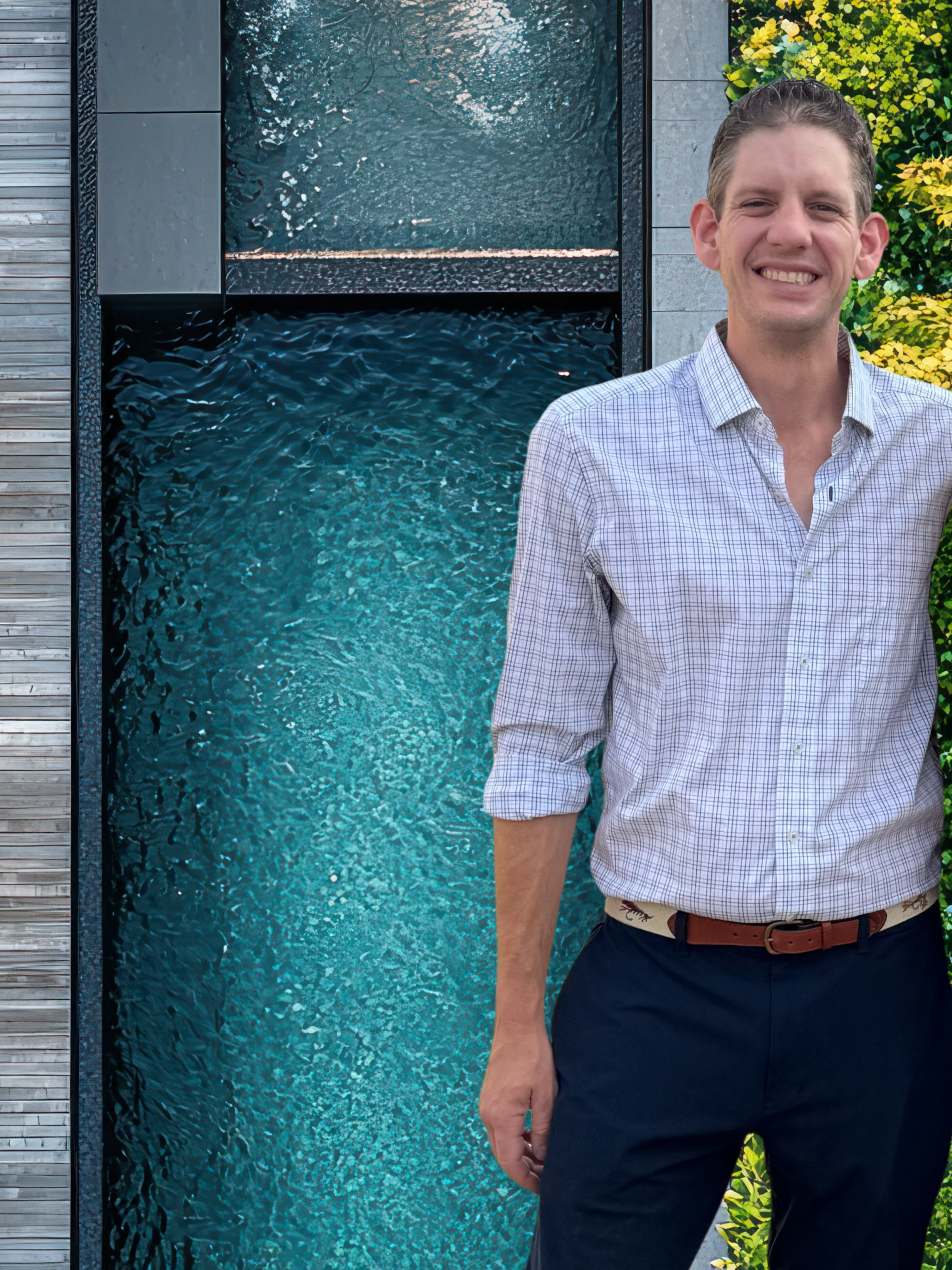 Feild Patten, Founder and Project Director at Cascades Dallas, standing beside a custom modern pool design.