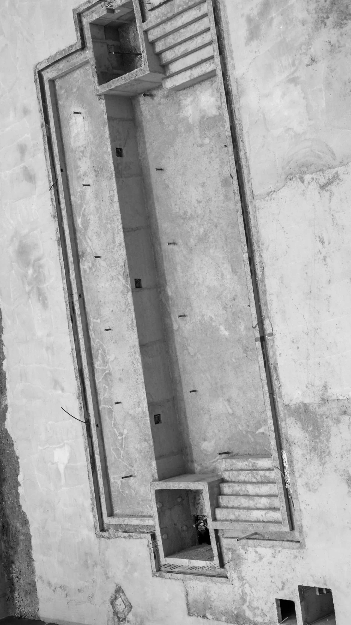 Overhead view of a Cascades pool during construction showing reinforced concrete shell and structural detailing before tile and finish application.