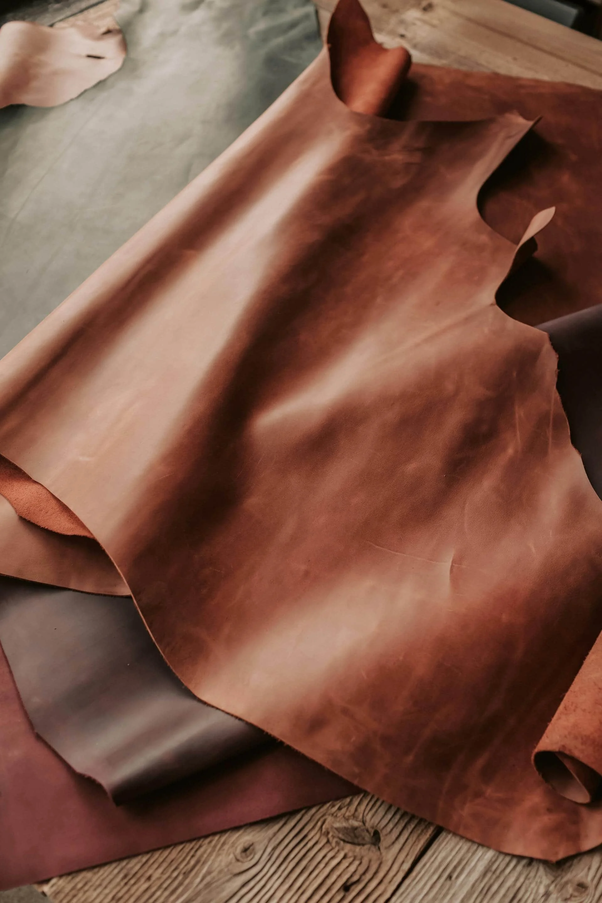 A roll of brown leather fabric on a wooden surface.