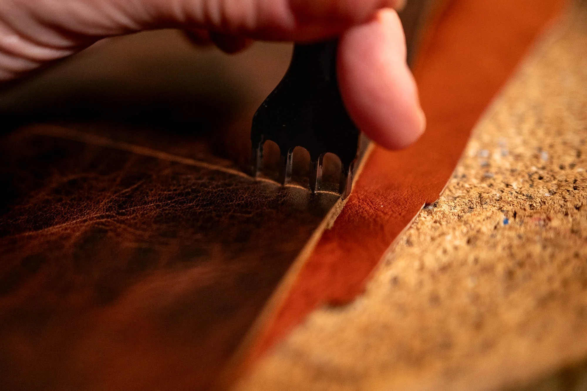 Close-up of a hand using a safety razor to shave a person's facial hair.