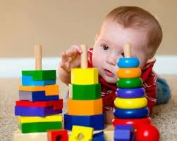 Baby playing with colorful stacking blocks.