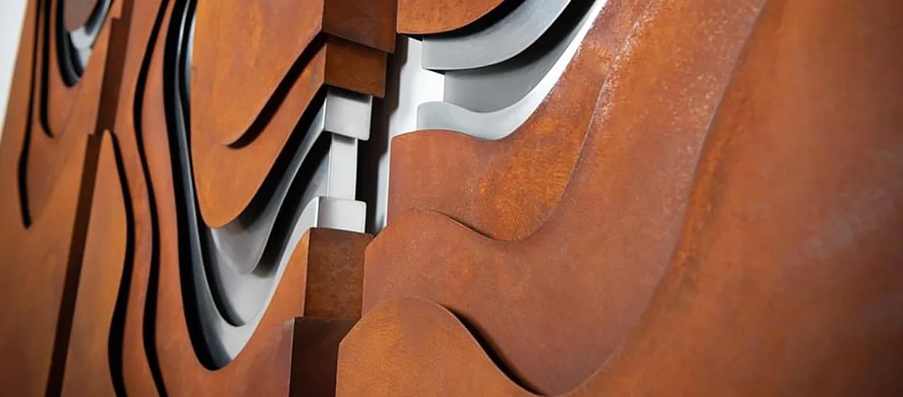 Close-up of rust and stainless steel metal abstract sculpture with curved, layered pieces.