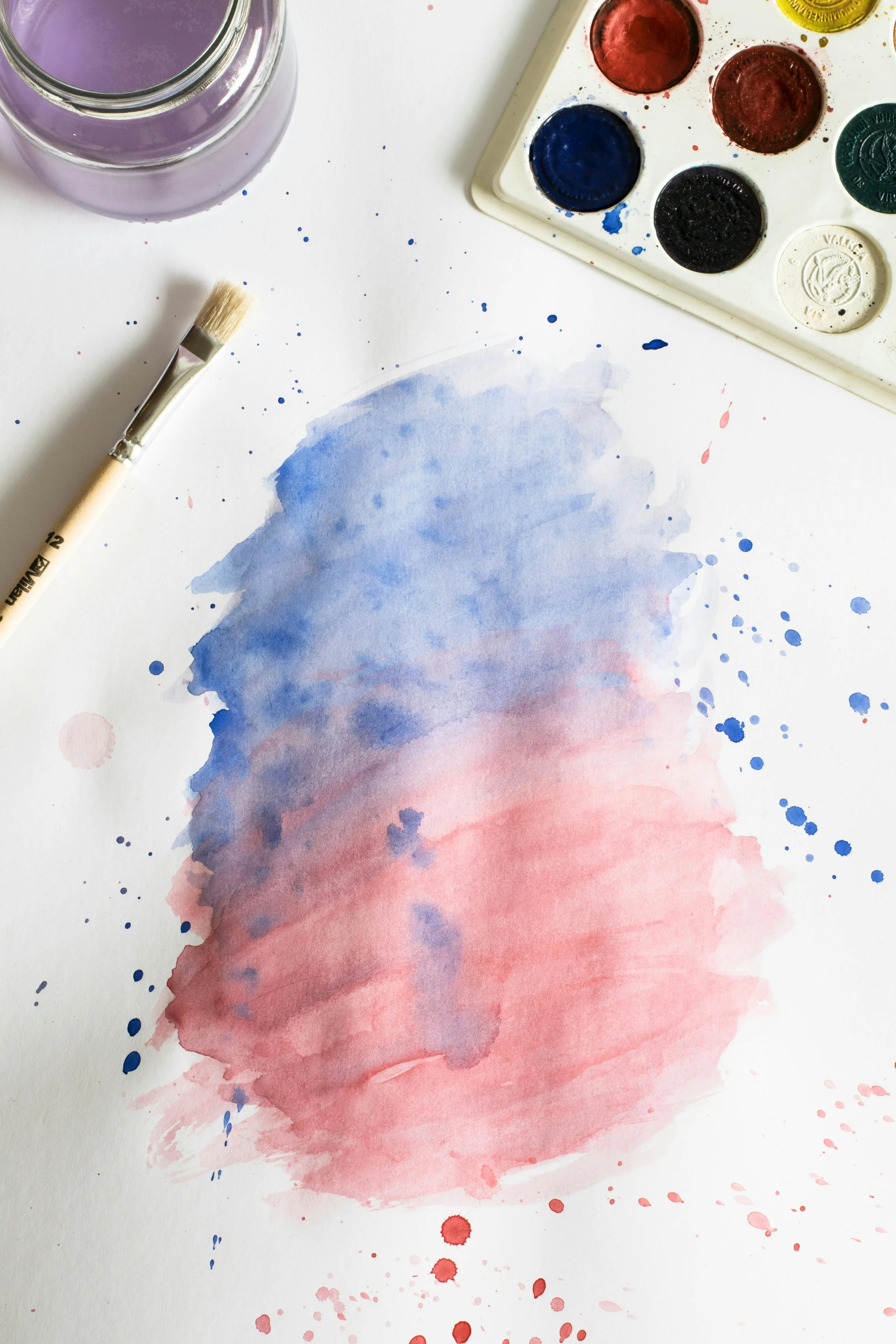 Blue and red watercolor painting with paints and brush