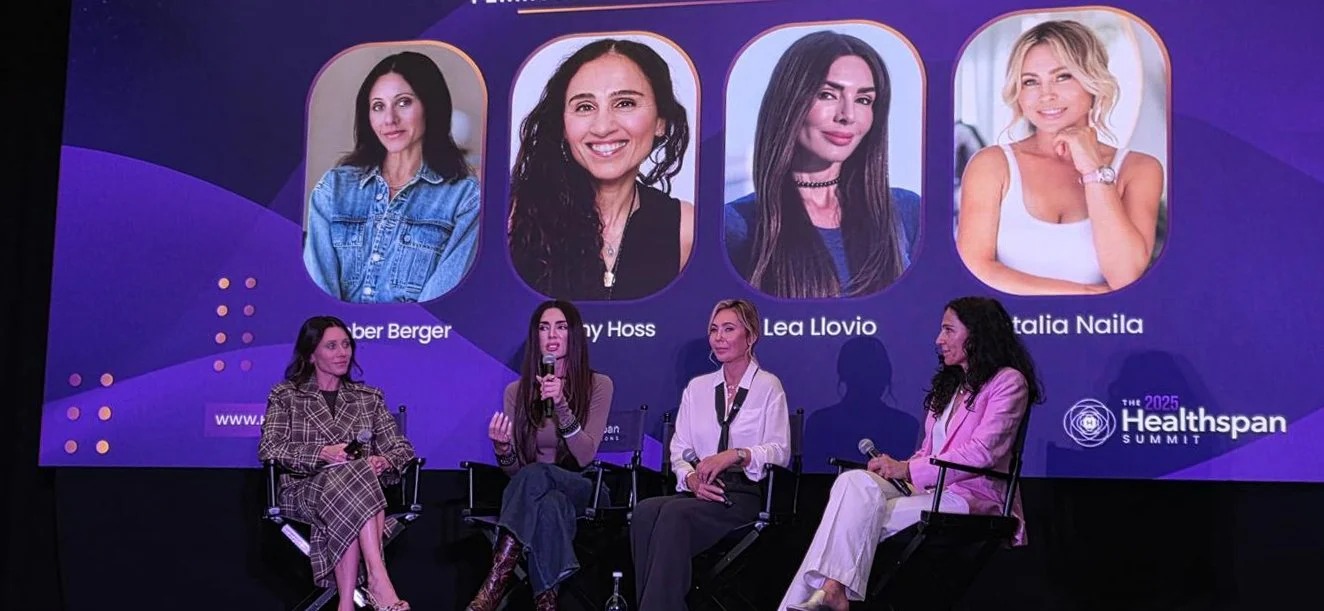 Four women sitting on a panel discussion at the 2025 Healthspan Summit, with a large screen behind them displaying pictures of four women, their names, and the summit logo.