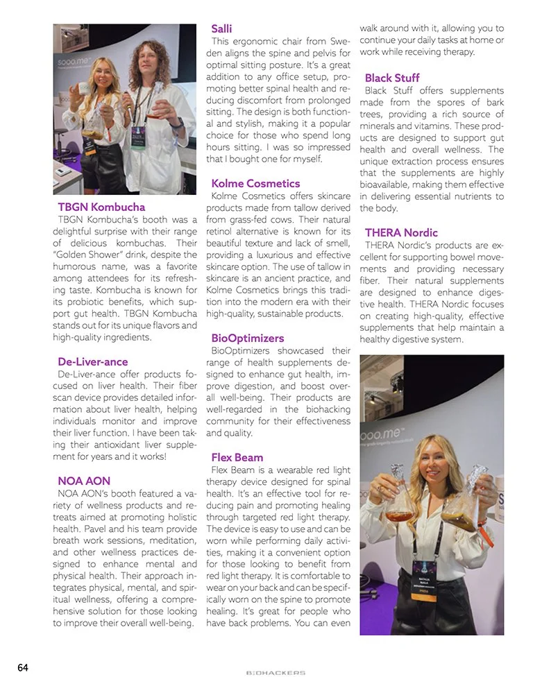 Two women at a booth, with one holding two glasses filled with a beverage, smiling. The booth has signage with the logo 'sapo.me' and information about health and wellness products.