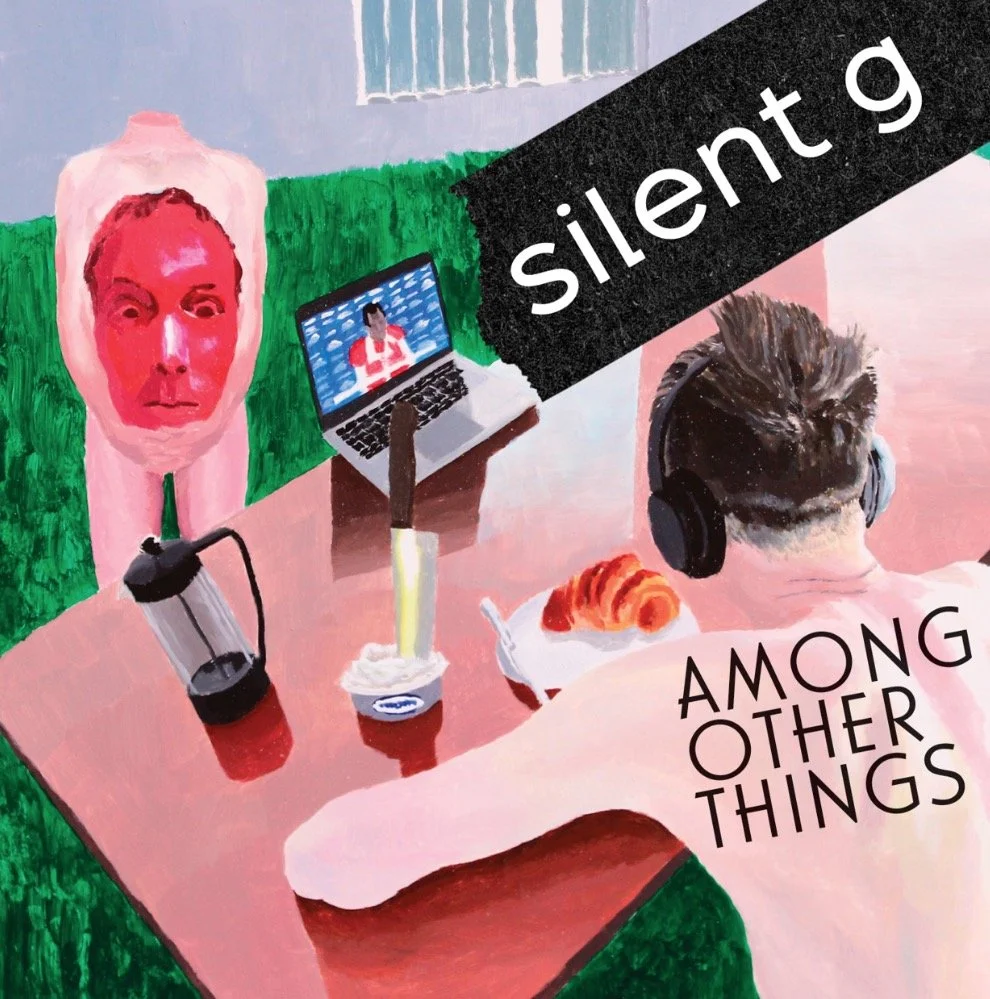 A person with short hair wearing headphones is sitting at a pink table, watching a video on a laptop. In front of them is a white cup with a yellow straw, a croissant, a red drink in a glass, and a large pink sculpture of a face with a bottle shape for a neck. The scene appears to be set outdoors with a grassy area and a blue sky in the background. The words 'silent' and 'AMONG OTHER THINGS' are overlaid on the image.