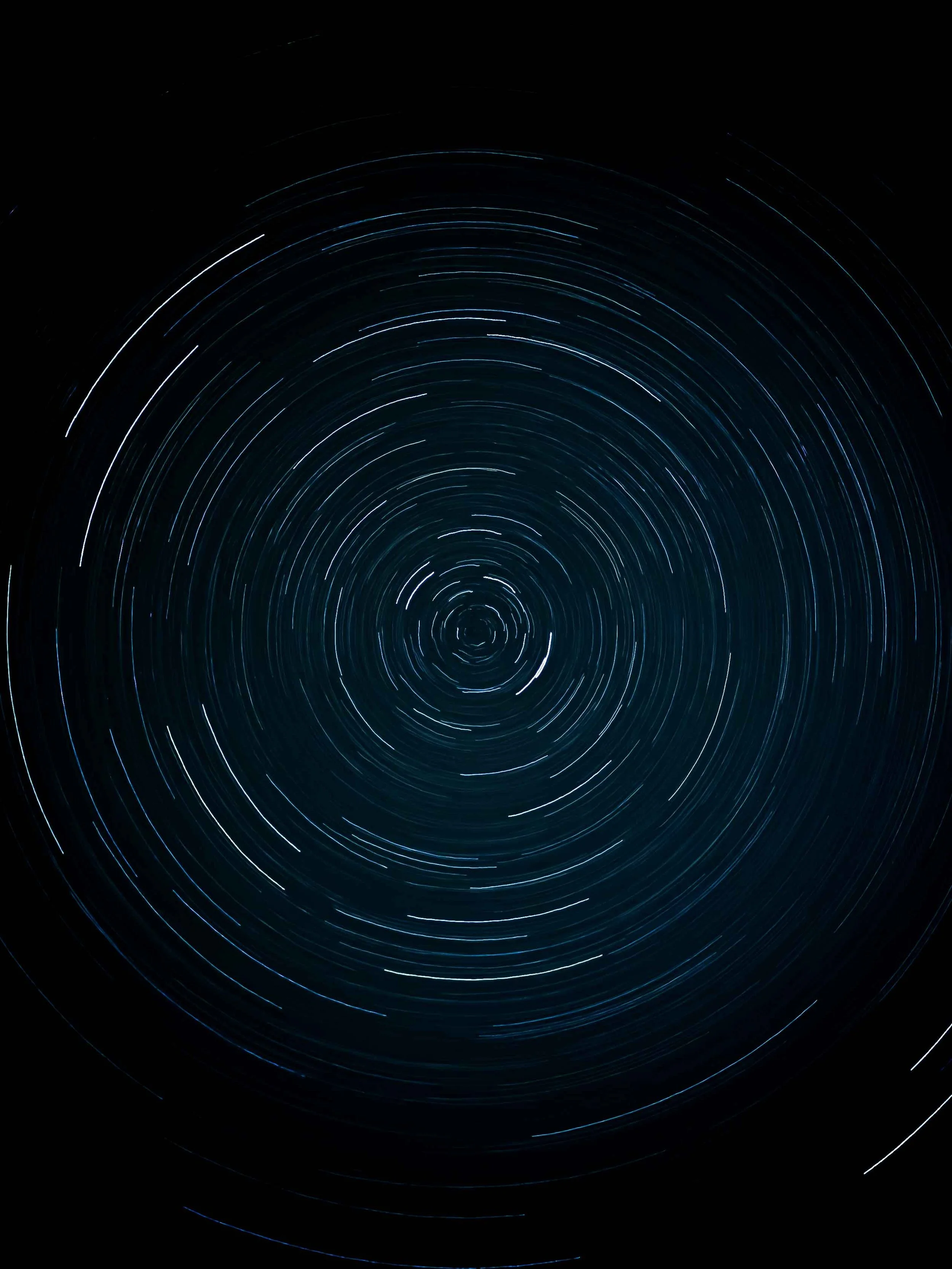 Long exposure photo of star trails in the night sky, creating circular patterns around the celestial pole.