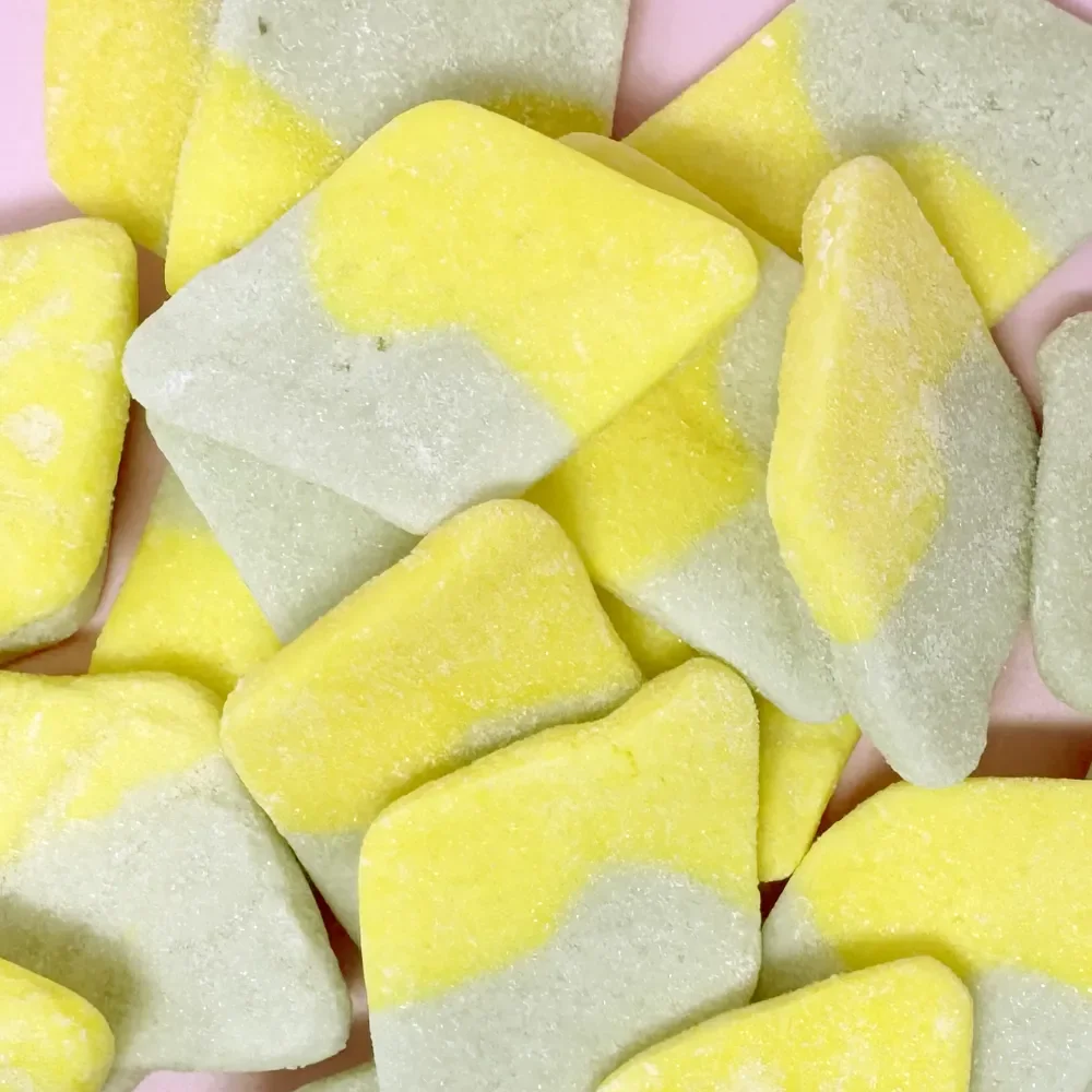 Close-up of Sugarloo World Swedish Diamonds Sour Tutti Frutti gummies showing soft, sugar-dusted yellow and green diamond-shaped candy pieces.