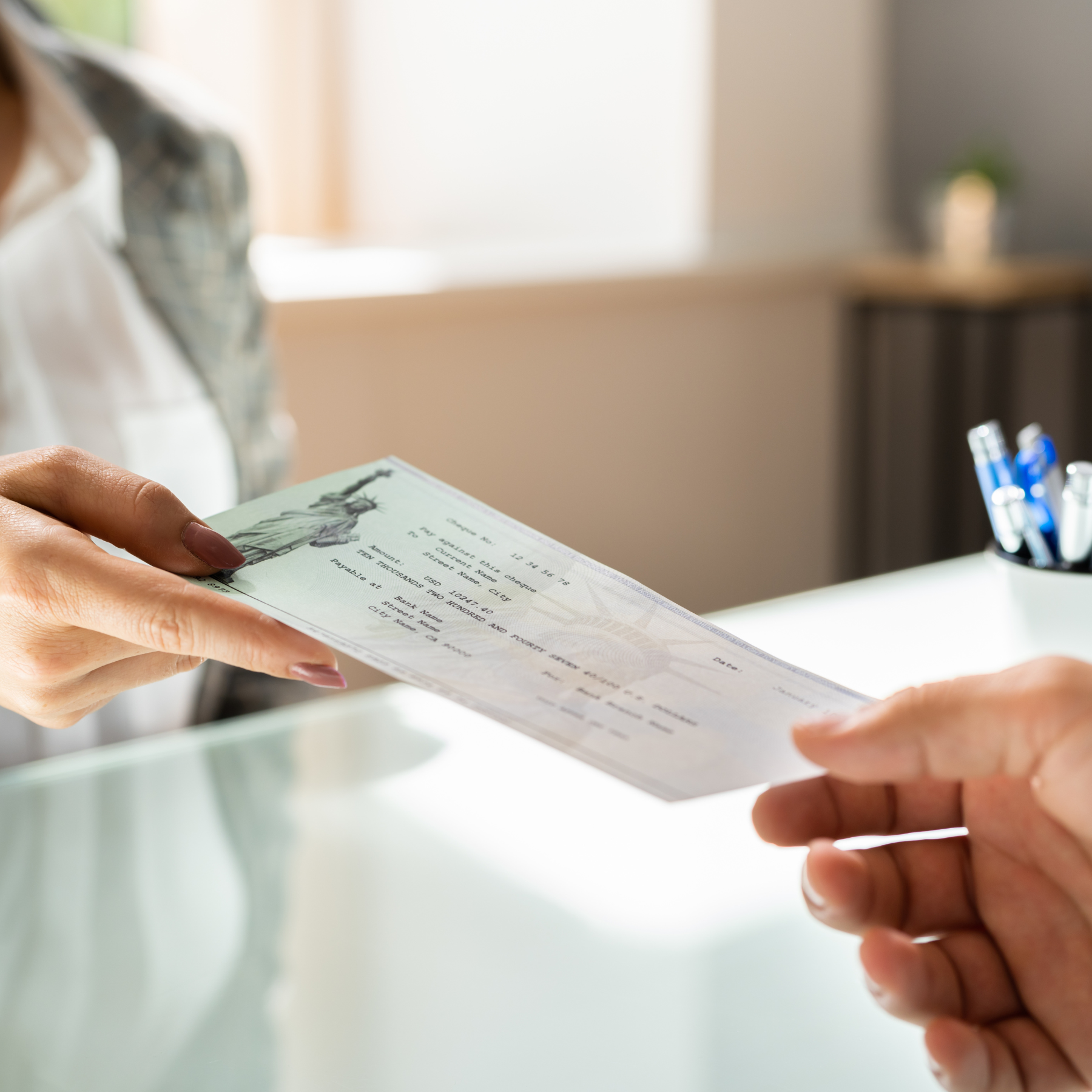 Person handing over a document to another person at a counter.