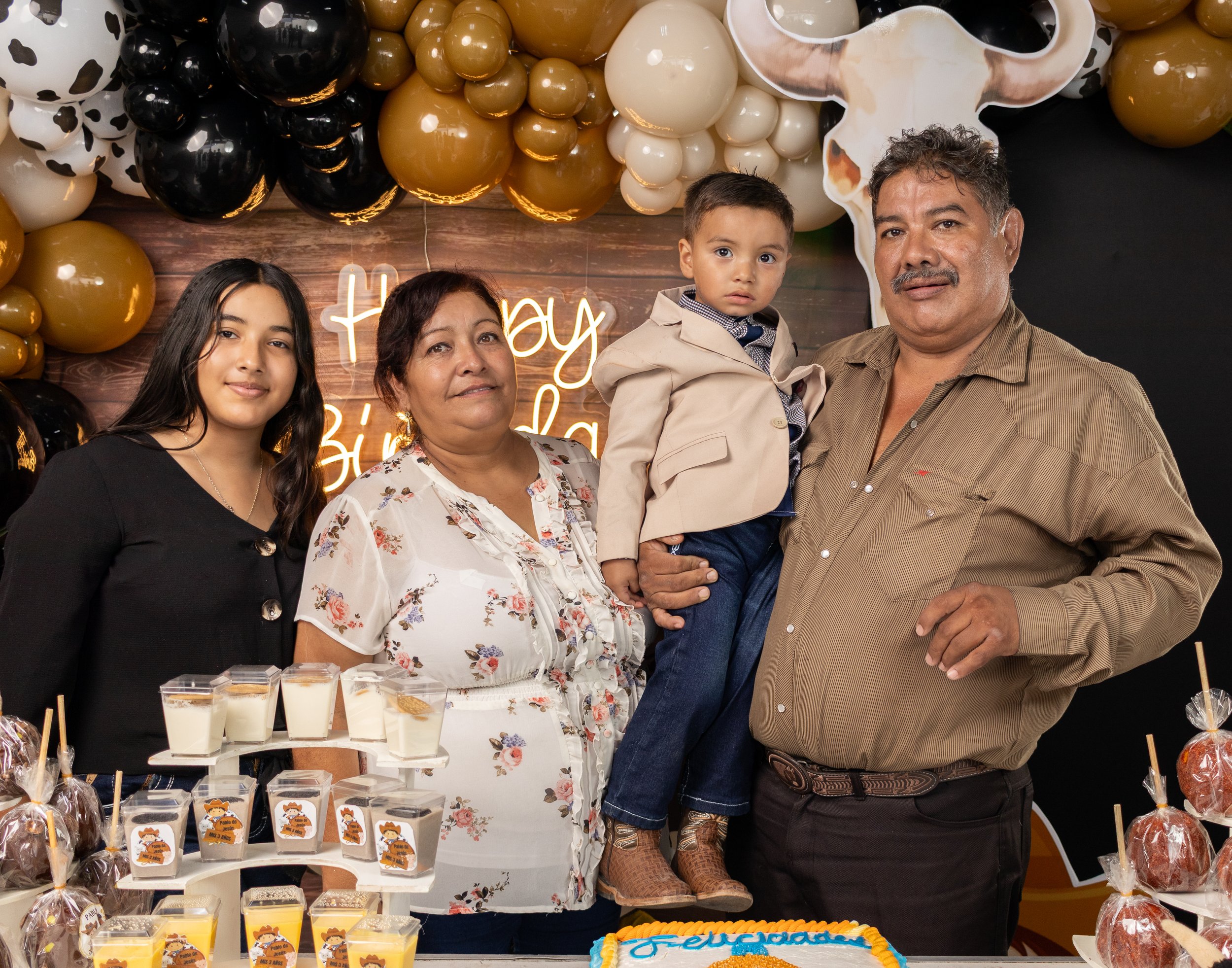 Realizamos un retrato con los abuelos estilo clásico frente a la mesa de postres, controlando alturas, sonrisas y balance de color para un recuerdo formal del evento.