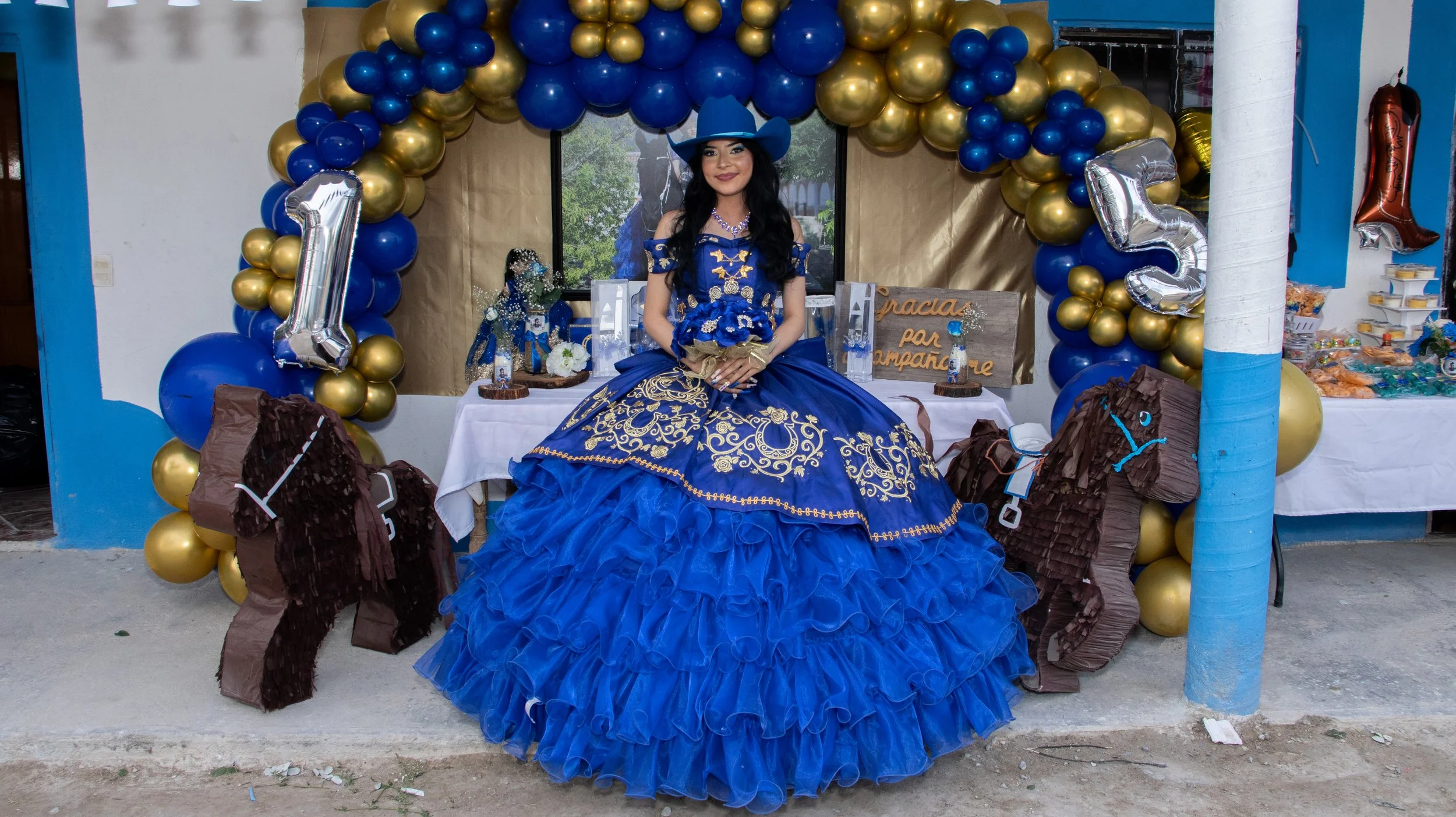 Toma central y simétrica para balancear decoración (azul/dorado) con la figura principal. Exposición pareja para colores fieles y detalle en mesa de recuerdos.