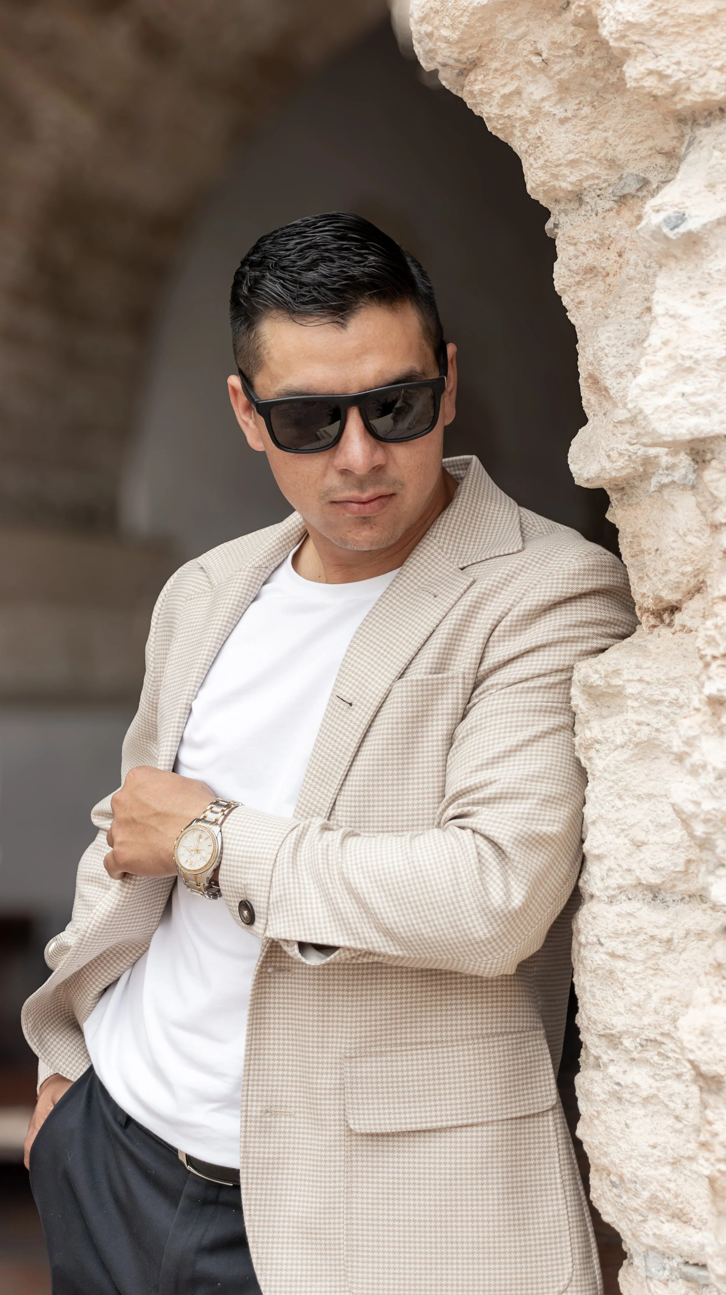 Buscamos un look sofisticado con luz suave lateral que define facciones y texturas del saco. Posamos la mano al reloj para sumar elegancia y lectura de accesorios.