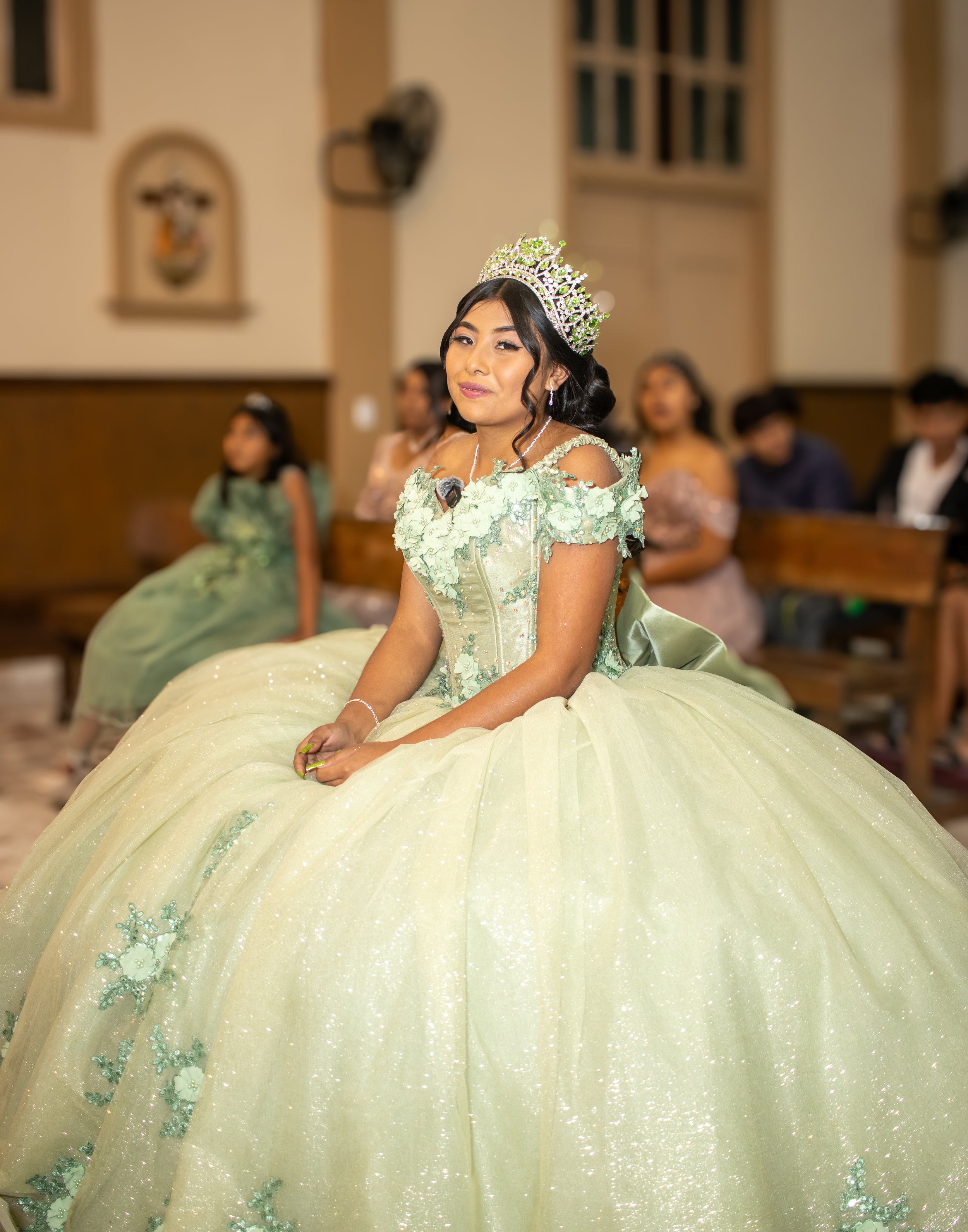 La escena transmite serenidad y significado, destacando la expresión natural y la presencia escénica de la quinceañera en un momento clave  de la ceremonia religiosa del evento.