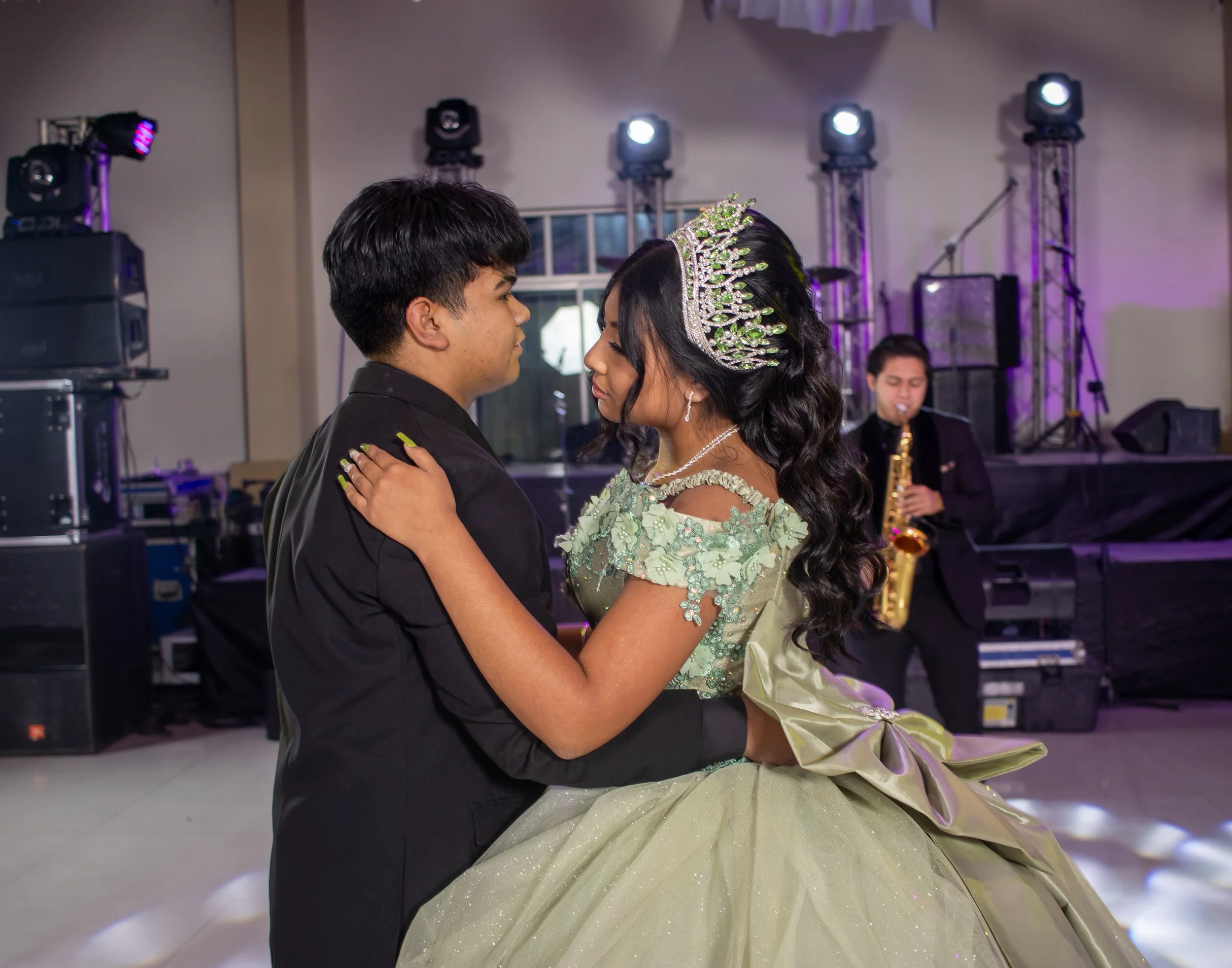 La escena comunica confianza y compañerismo; es el vals con el chambelán principal, uno de los momentos más representativos de una celebración de XV años.