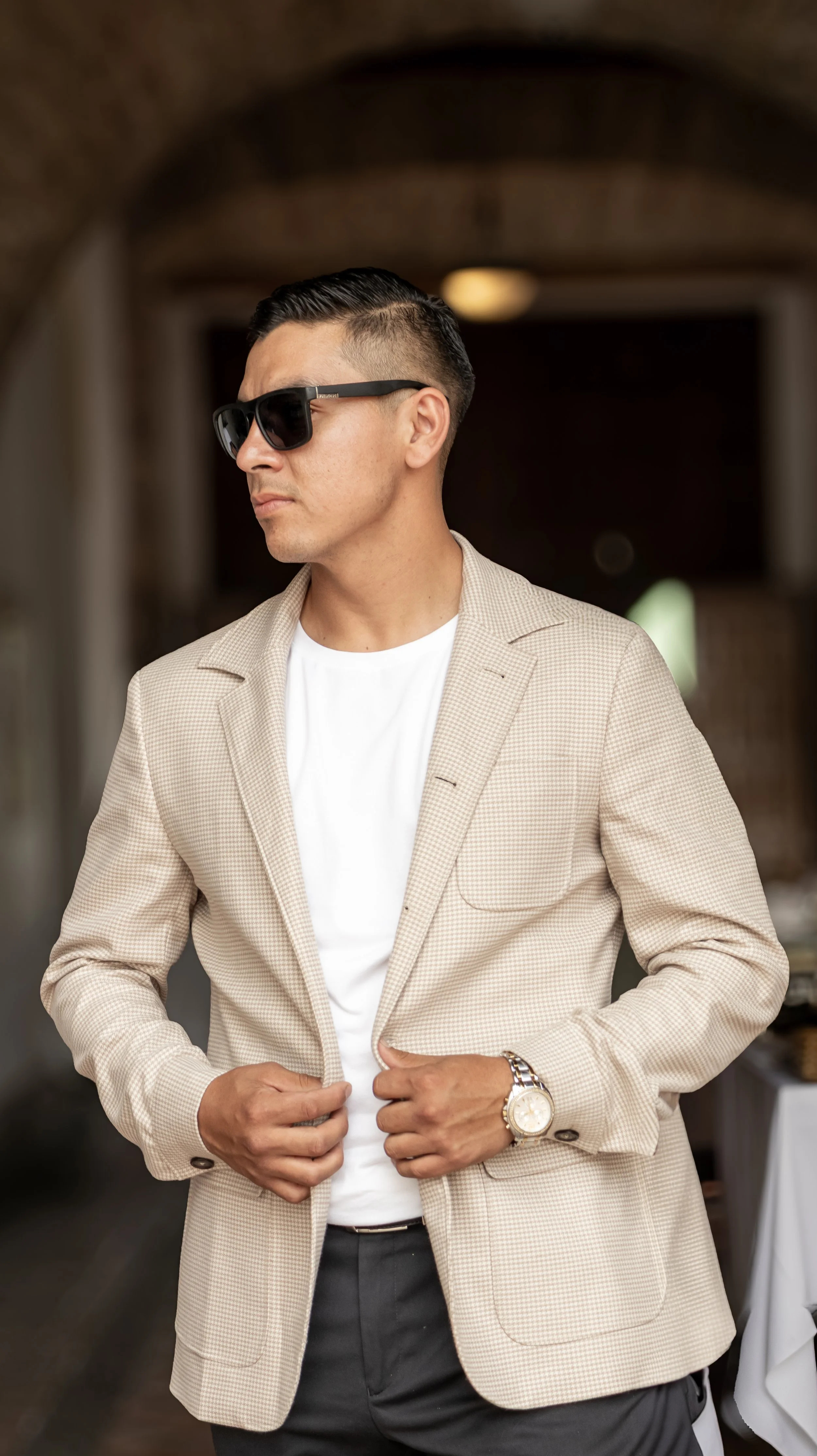 Capturamos el movimiento de abrochar la chaqueta para transmitir naturalidad. Fondo neutro y desenfoque controlado que mantienen toda la atención en el modelo.