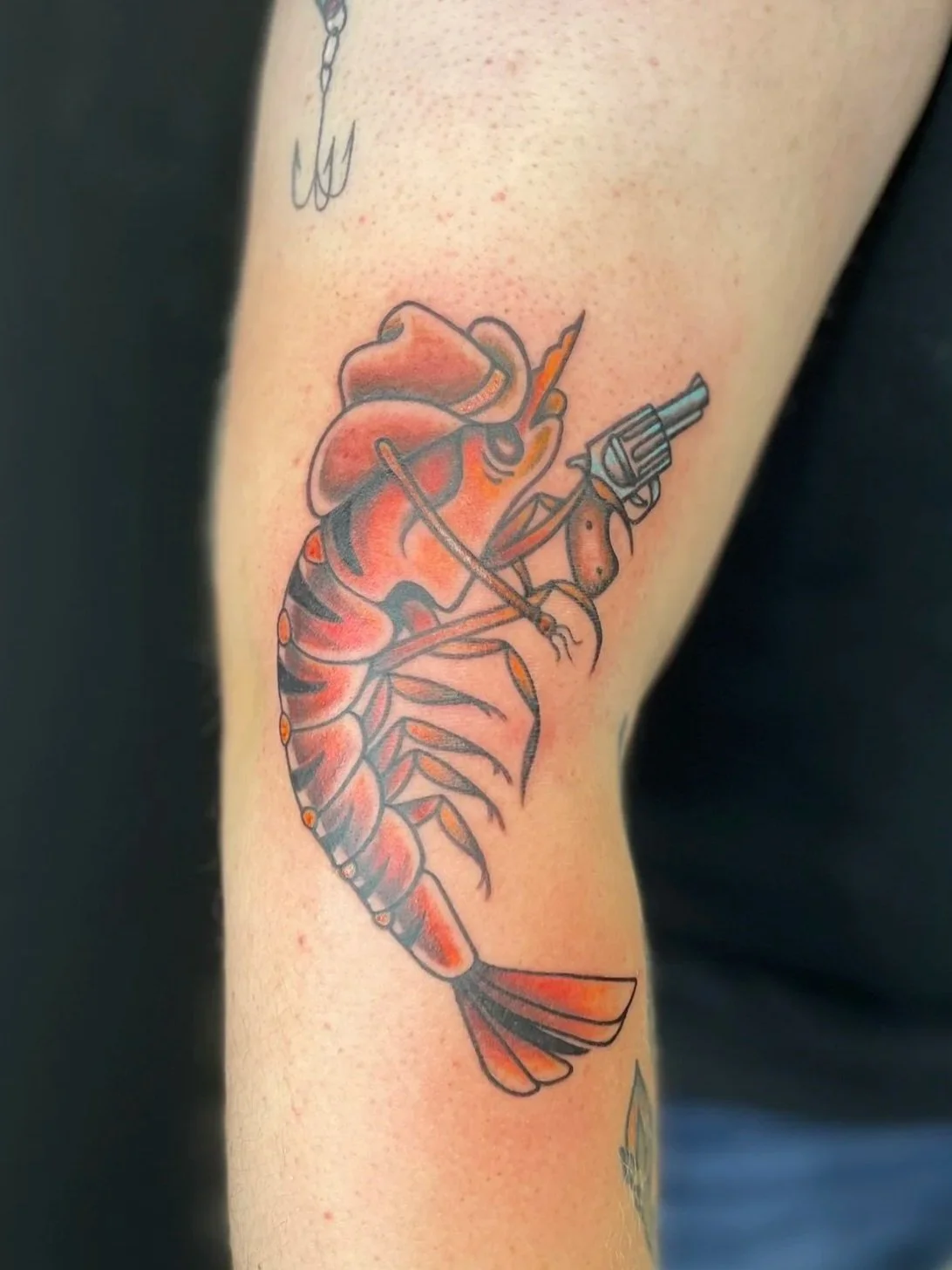 traditional tattoo of a shrimp holding a revolver, tattooed by Zing Phelps, in Cedar Rapids, Iowa
