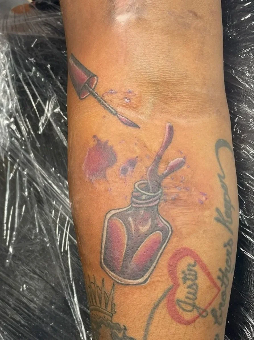 Tattoo of a nail polish jar, spilled purple ink splashes, tattooed by Zing Phelps, in Cedar Rapids, Iowa