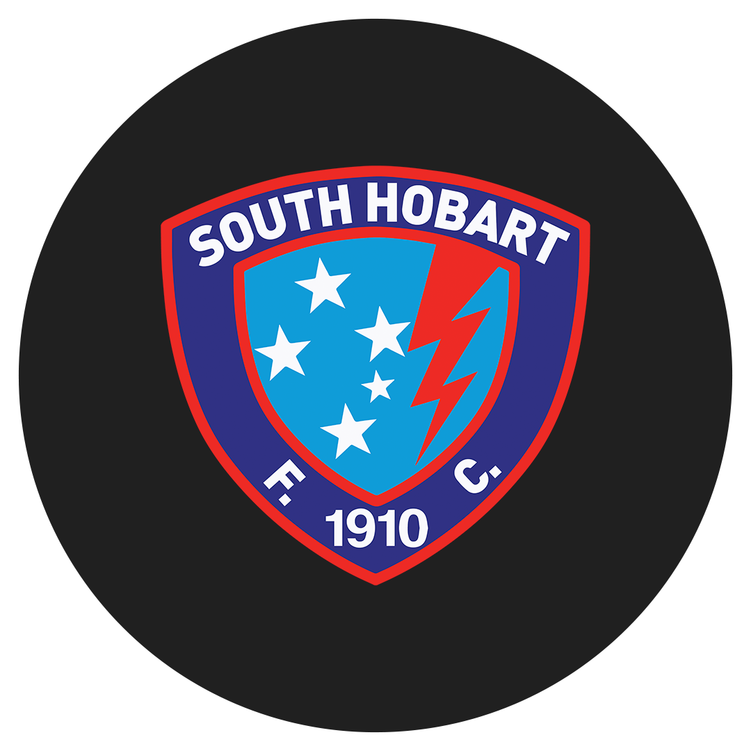 South Hobart Football Club badge with a blue shield containing white stars and a red lightning bolt, surrounded by a navy blue border with red outline, displaying 'SOUTH HOBART F.C.' and '1910'.