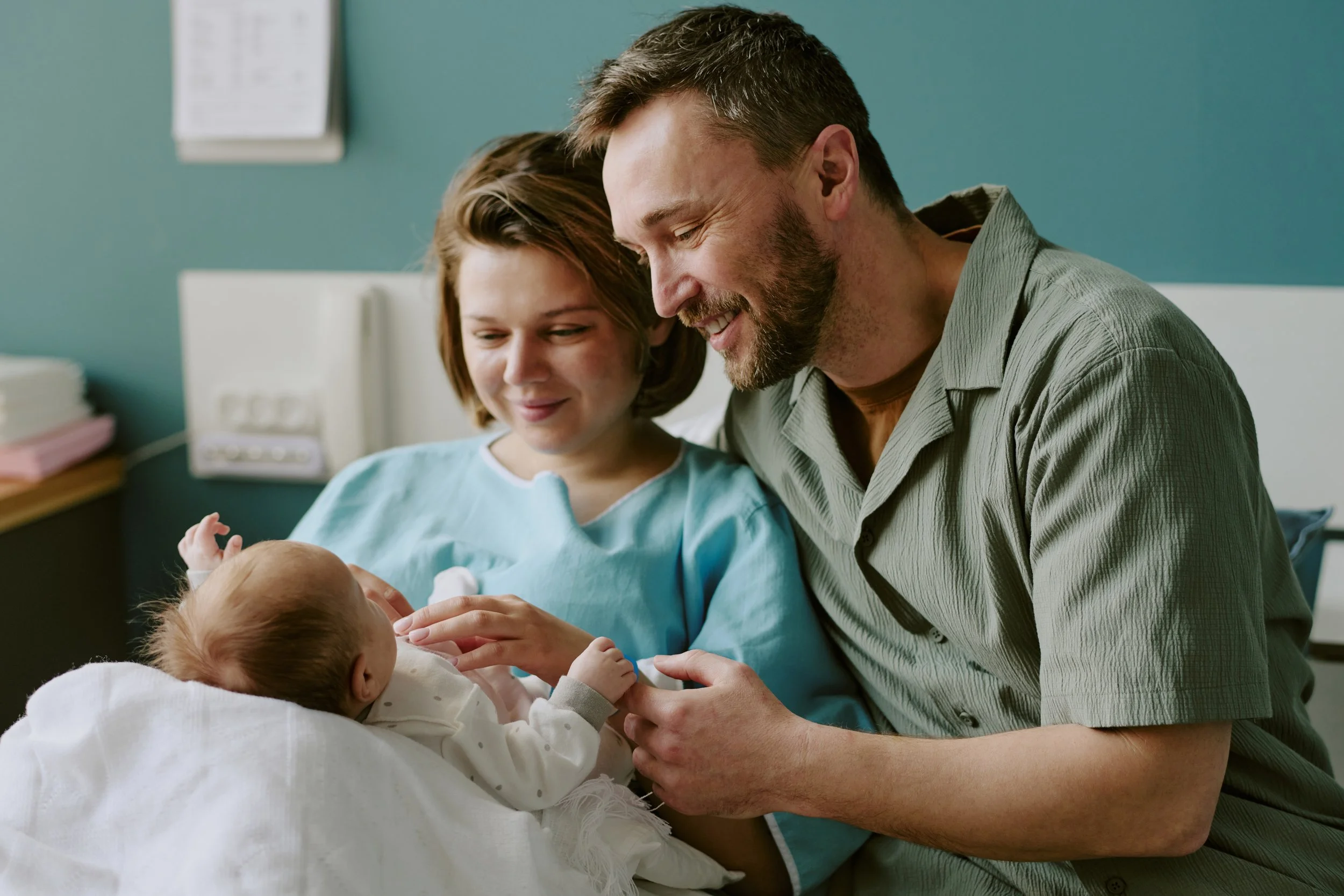 Family looking lovingly at newborn baby