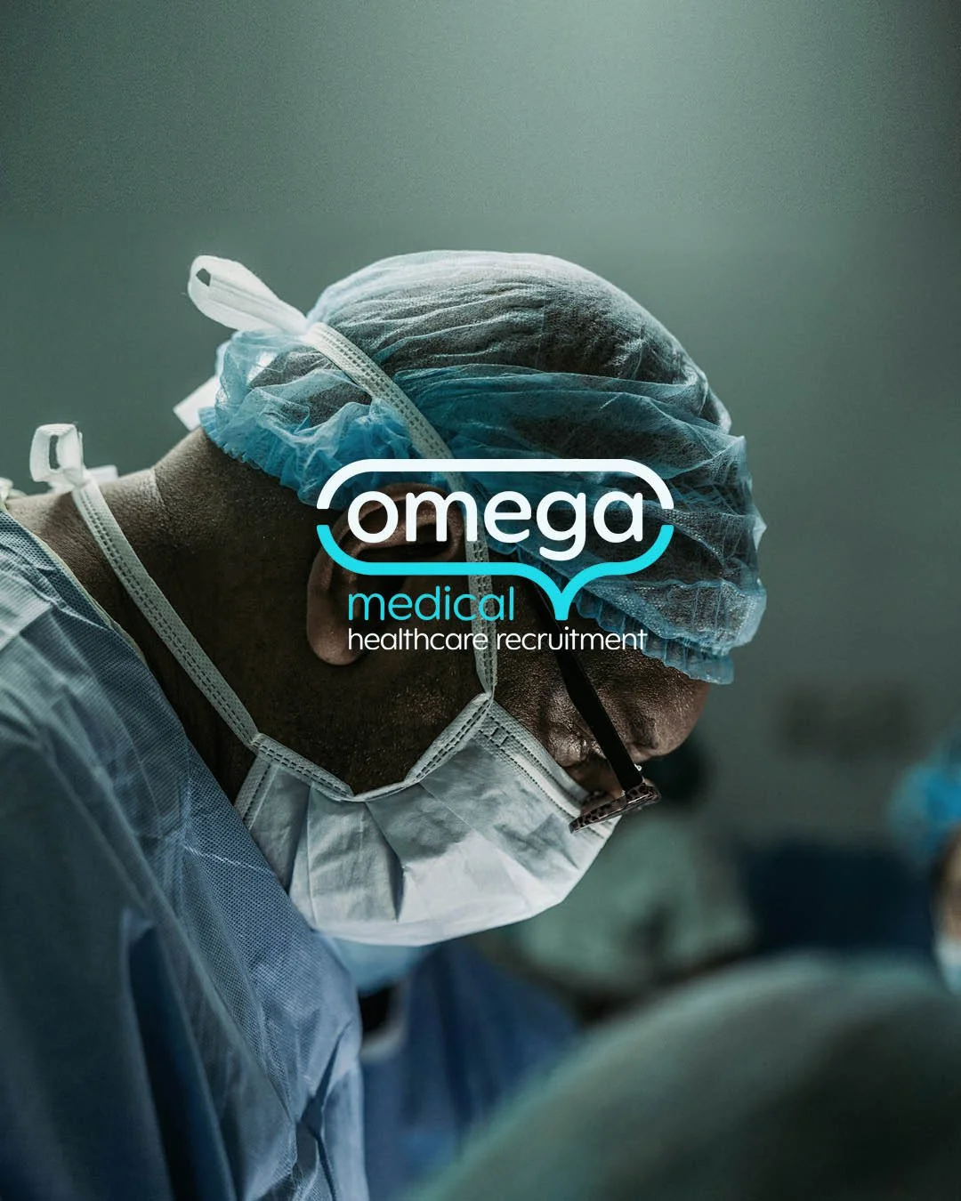 A surgeon wearing a blue hair cap, face mask, and glasses performing a medical procedure, with the Omega Medical Healthcare Recruitment logo overlaid.