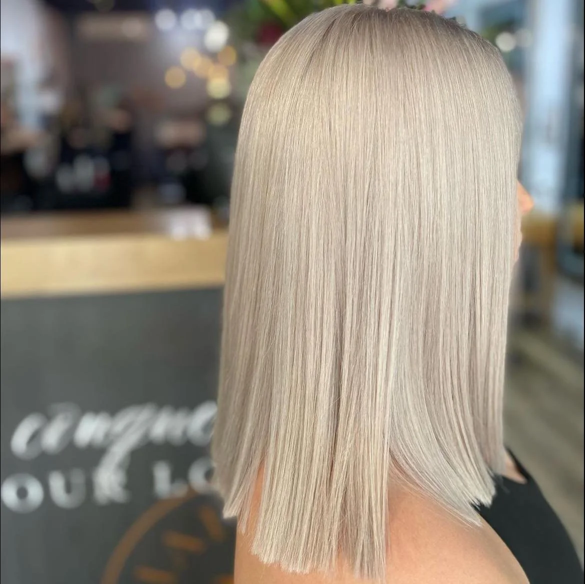 Blonde, straight, shoulder-length haircut with a blunt cut at the ends.