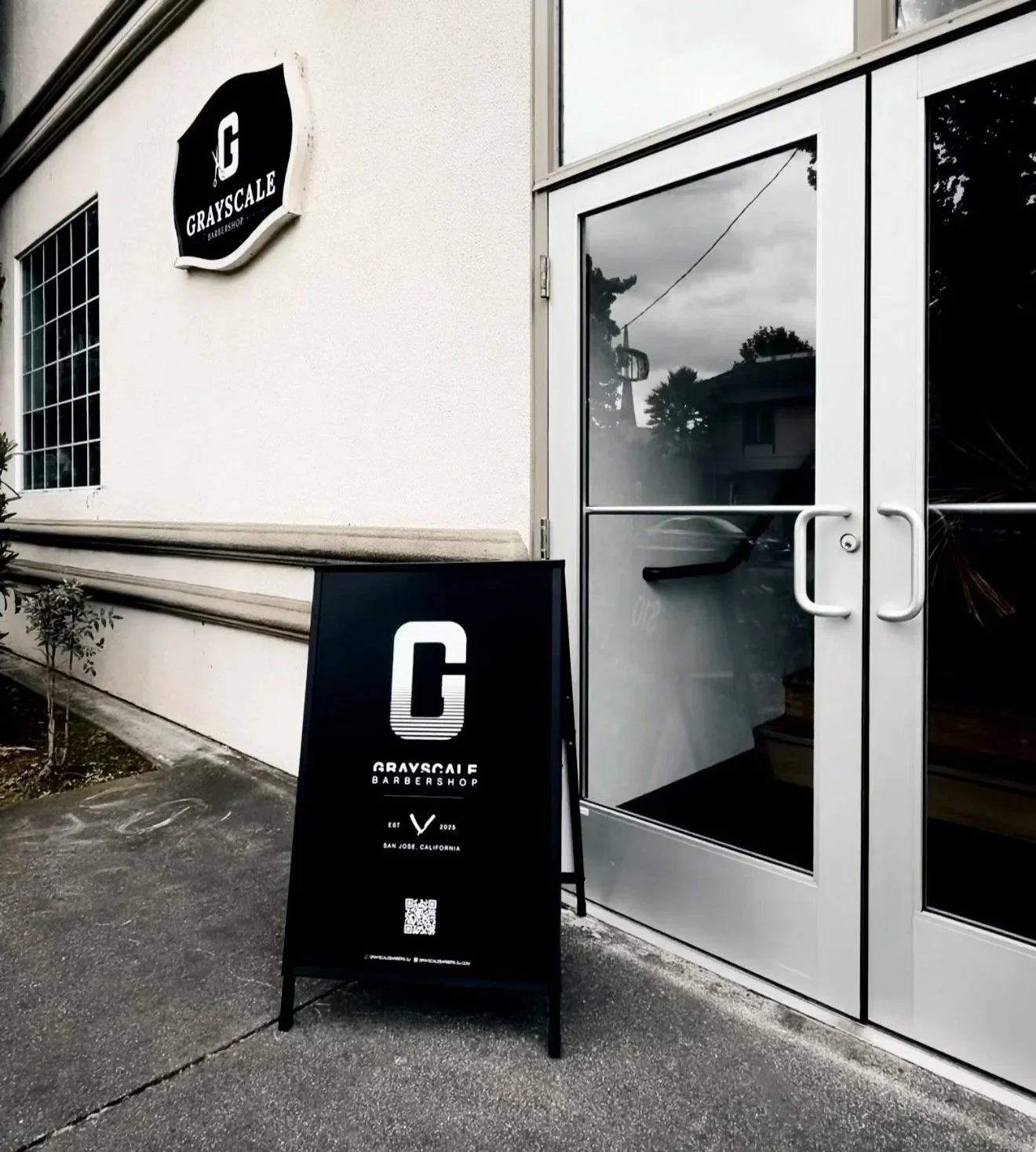 Front end of establishment, with grayscale barbers sj  sign