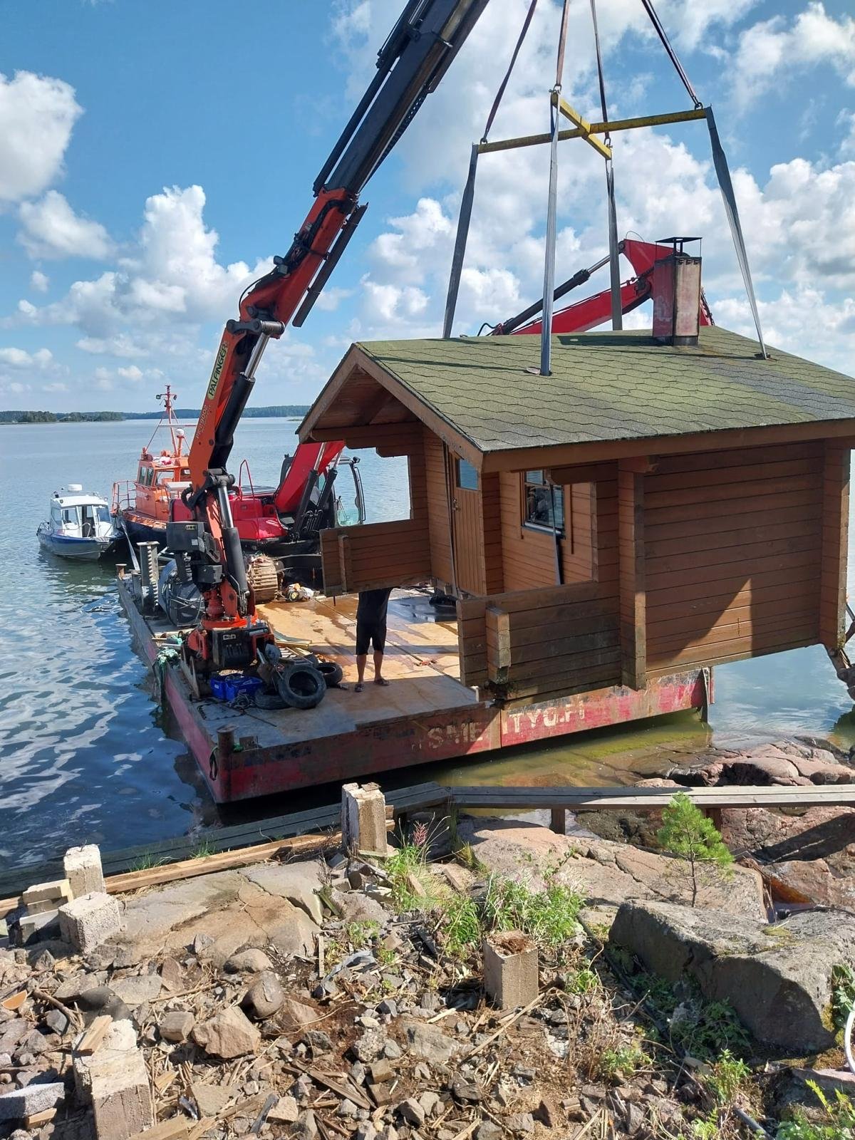 JS Merityö Oy:n alus kuljettaa mökkipakettia ja puutavaraa meriteitse saaristossa.