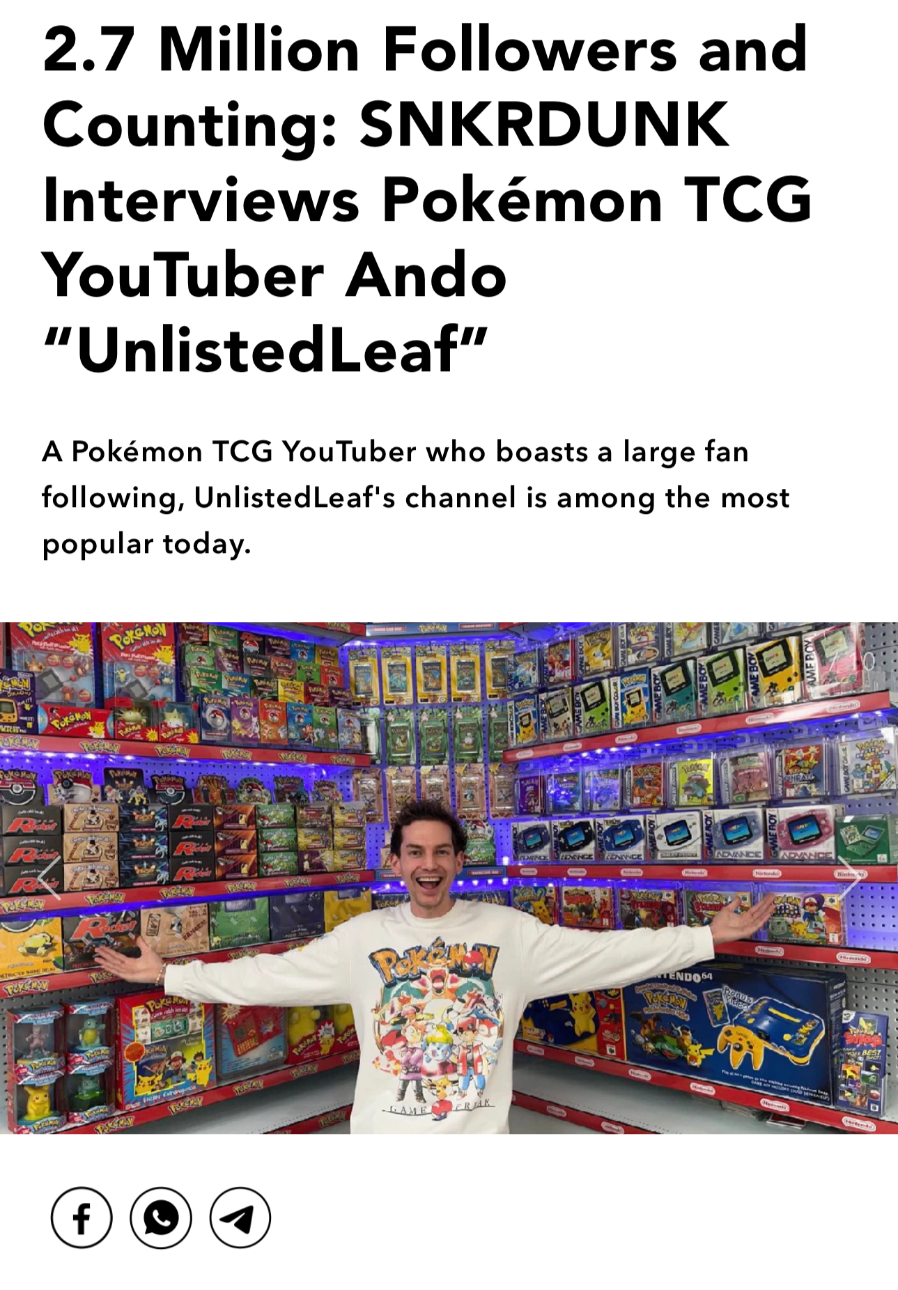 A young man wearing a white Pokémon-themed sweatshirt stands with arms outstretched in a store aisle filled with Pokémon toys and merchandise, smiling at the camera.