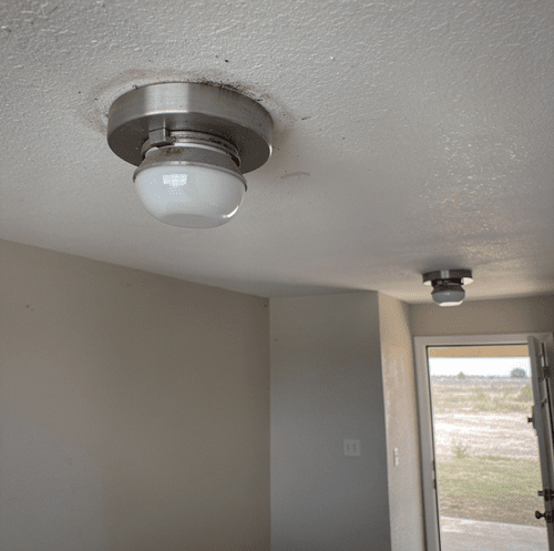 dim living room light bulb against dark wall outlet
