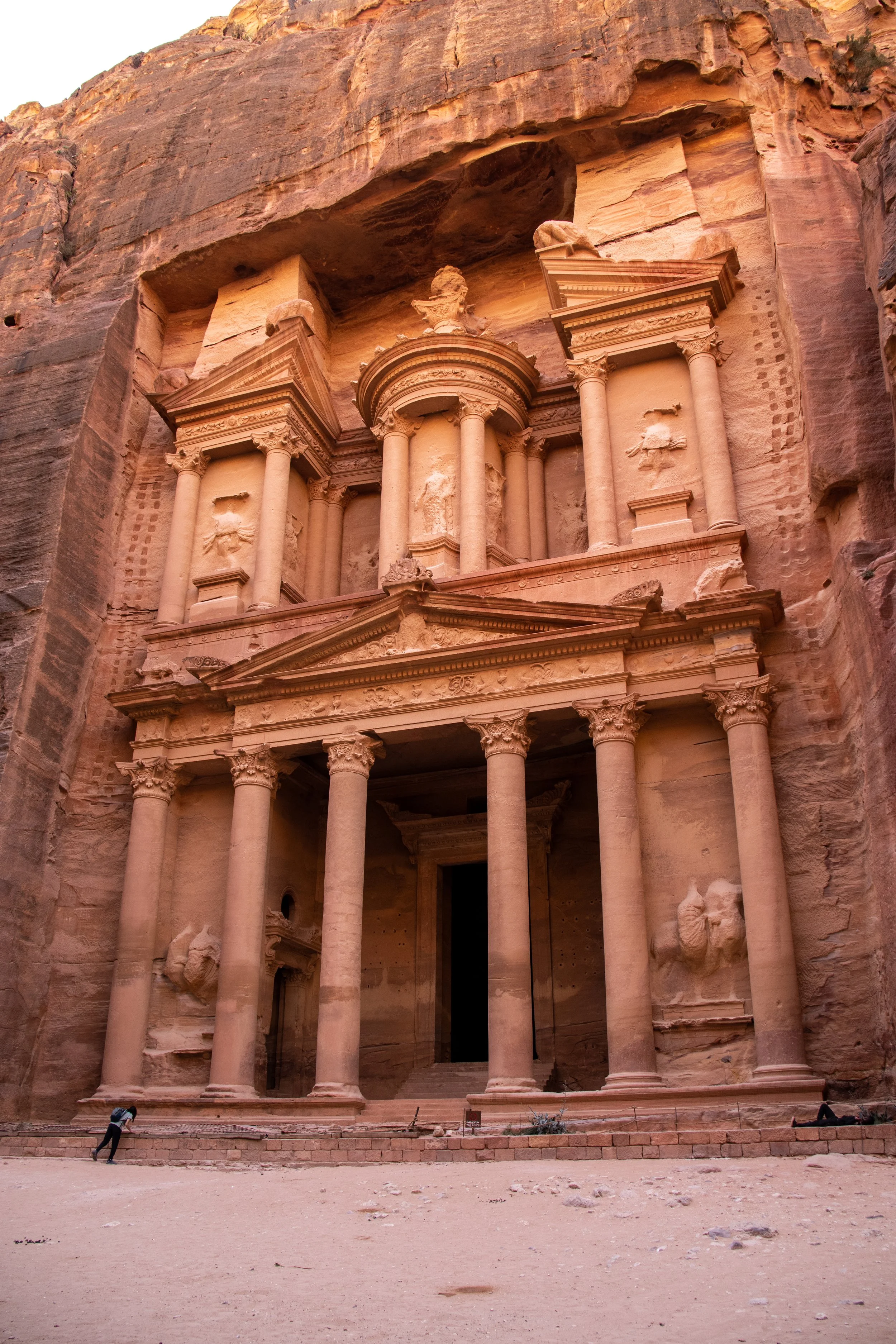Fachada do antigo santuário de Petra, na Jordânia, esculpida na rocha, com colunas e detalhes arquitetônicos antigos.