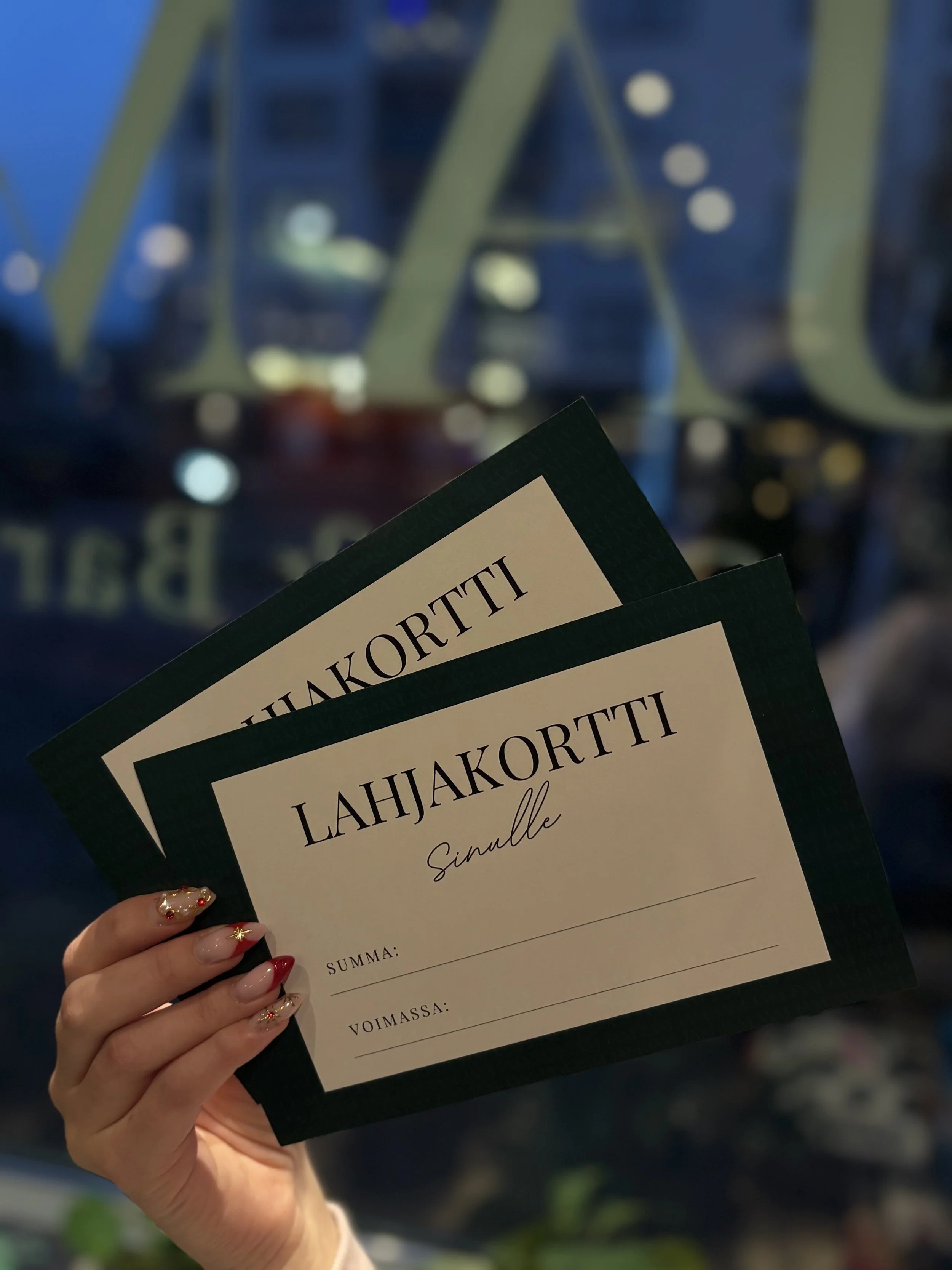 Kädessä kolme lahjakorttia, joissa lukee 'Lahjakortti Sinulle'.