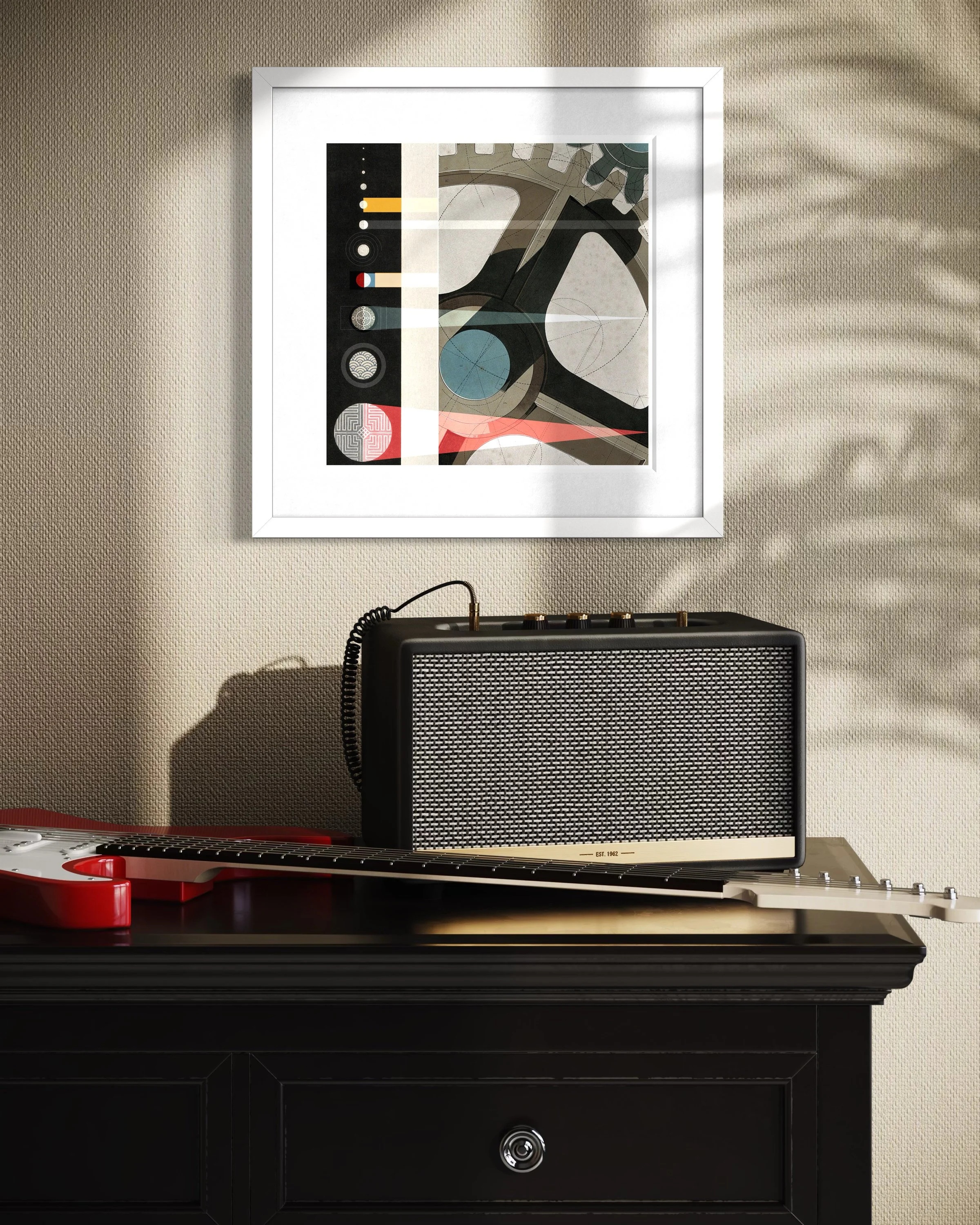 The Planets fine-art print in a white gallery frame displayed on a beige wall above a guitar amplifier and electric guitar, with soft sunlight and plant shadows falling across the wall