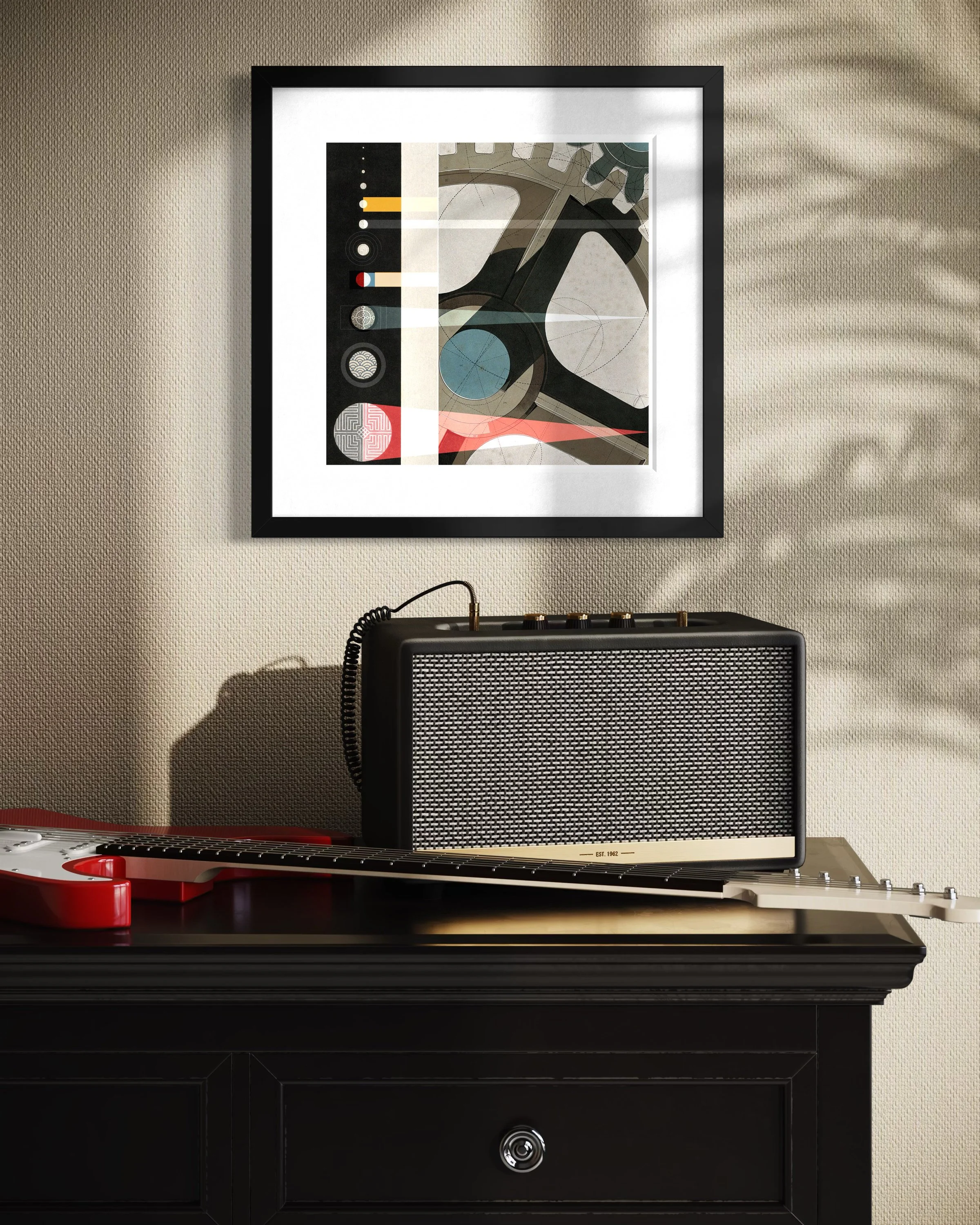 The Planets fine-art print in a black gallery frame displayed on a beige wall above a guitar amplifier and electric guitar, with dramatic natural light and plant shadows across the scene