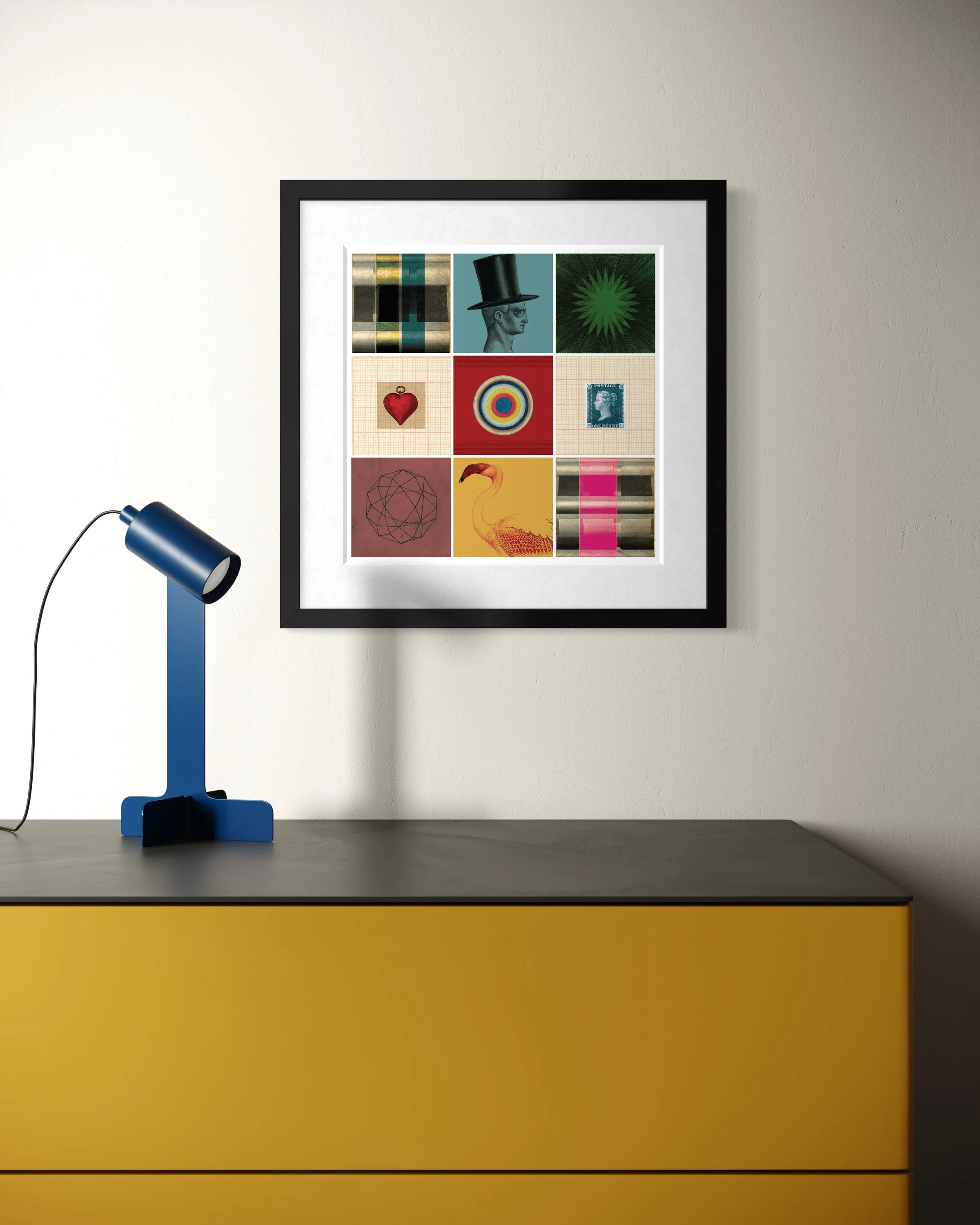 Curiosity collage print in a black frame hanging above a yellow cabinet, with a blue modern desk lamp on the left casting a soft shadow on the wall.