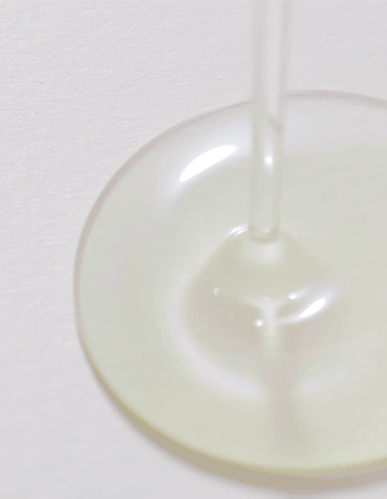 Close-up of white liquid being poured into a clear glass container