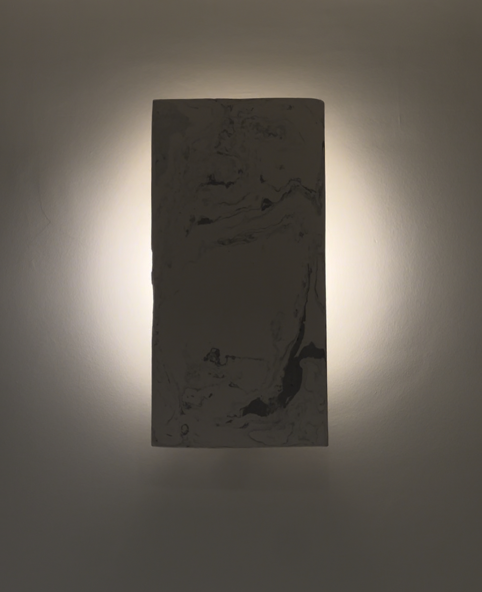 Suspension murale rectangulaire avec éclairage indirect, aspect marbré en gris et blanc.