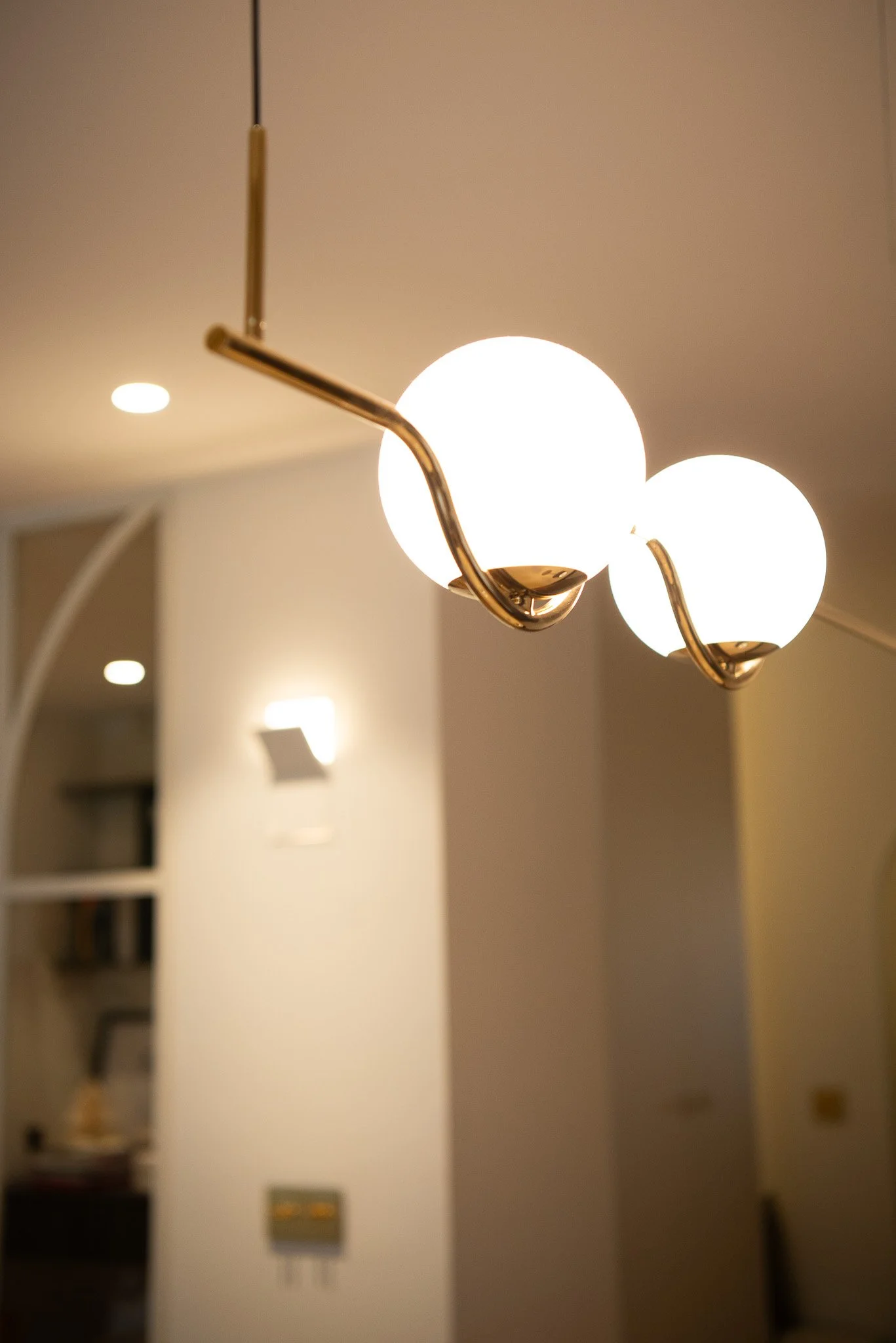 Lustre avec deux globes lumineux ronds suspendu au plafond dans une pièce intérieure