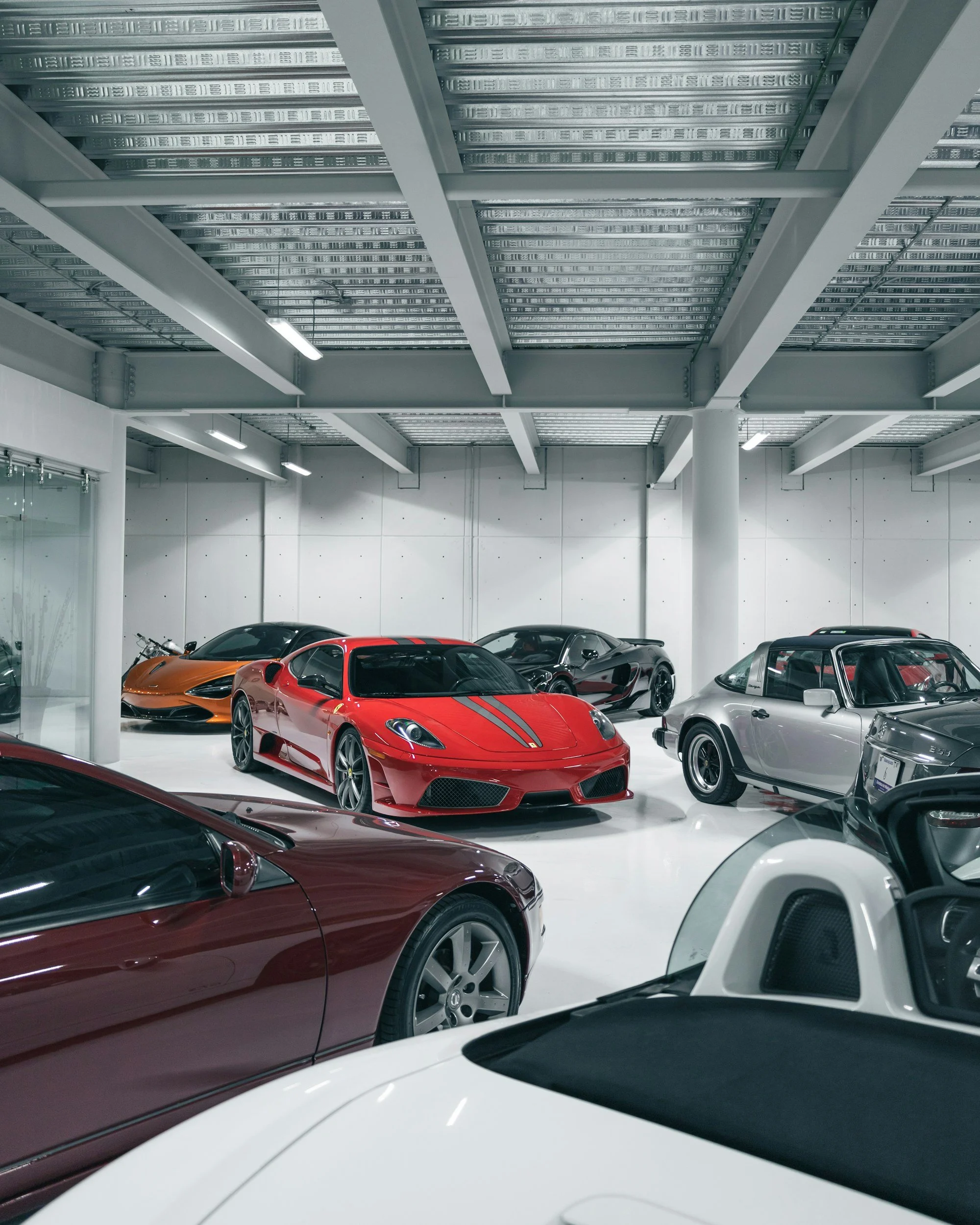 Luxury sports cars displayed inside a modern dealership showroom, supporting an online body language course option for automotive sales professionals.