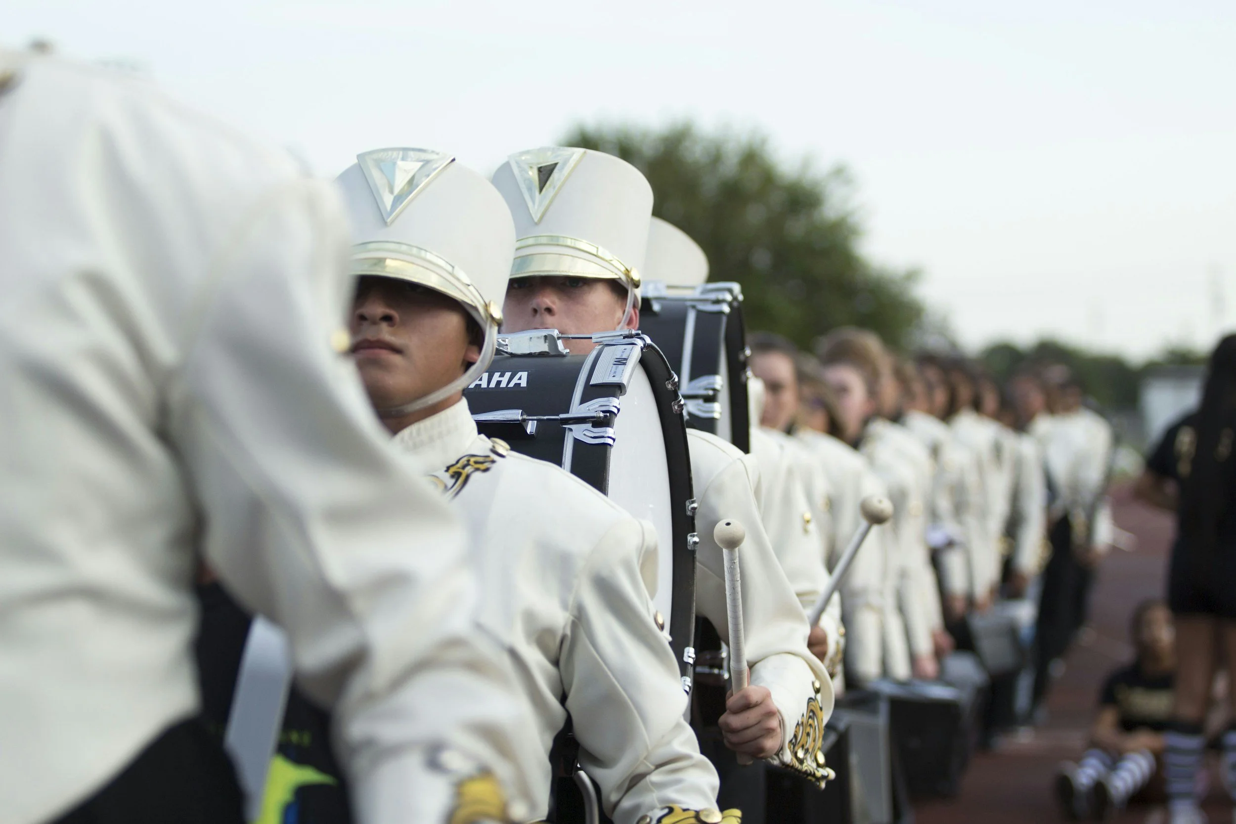 Marching band students lined up in uniform, representing school sponsorship outreach and fundraising strategy for bands, athletics, and booster programs.